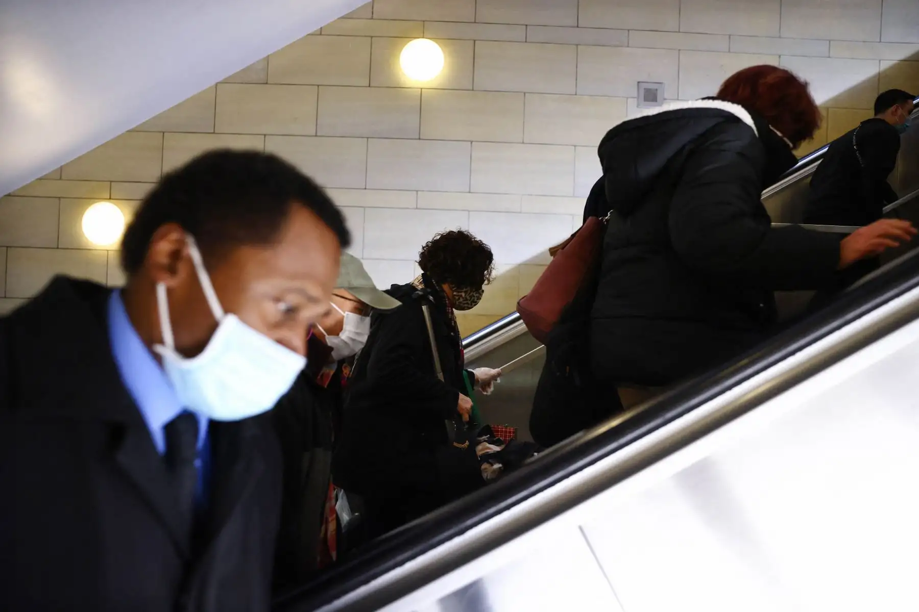 Personas usan cubiertas faciales al salir de un tren Metro Rail en Los Ángeles, California. Foto: AFP