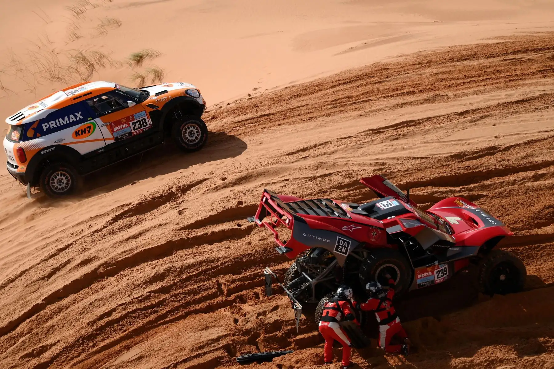 La piloto española de Mini Laia Sanz y el copiloto Murizio Gerini de Italia, compiten mientras otro equipo examina su coche durante la Etapa 3 del Rally Dakar 2022 entre las áreas saudíes de al-Artawiya y al-Qaysumah. Foto: AFP