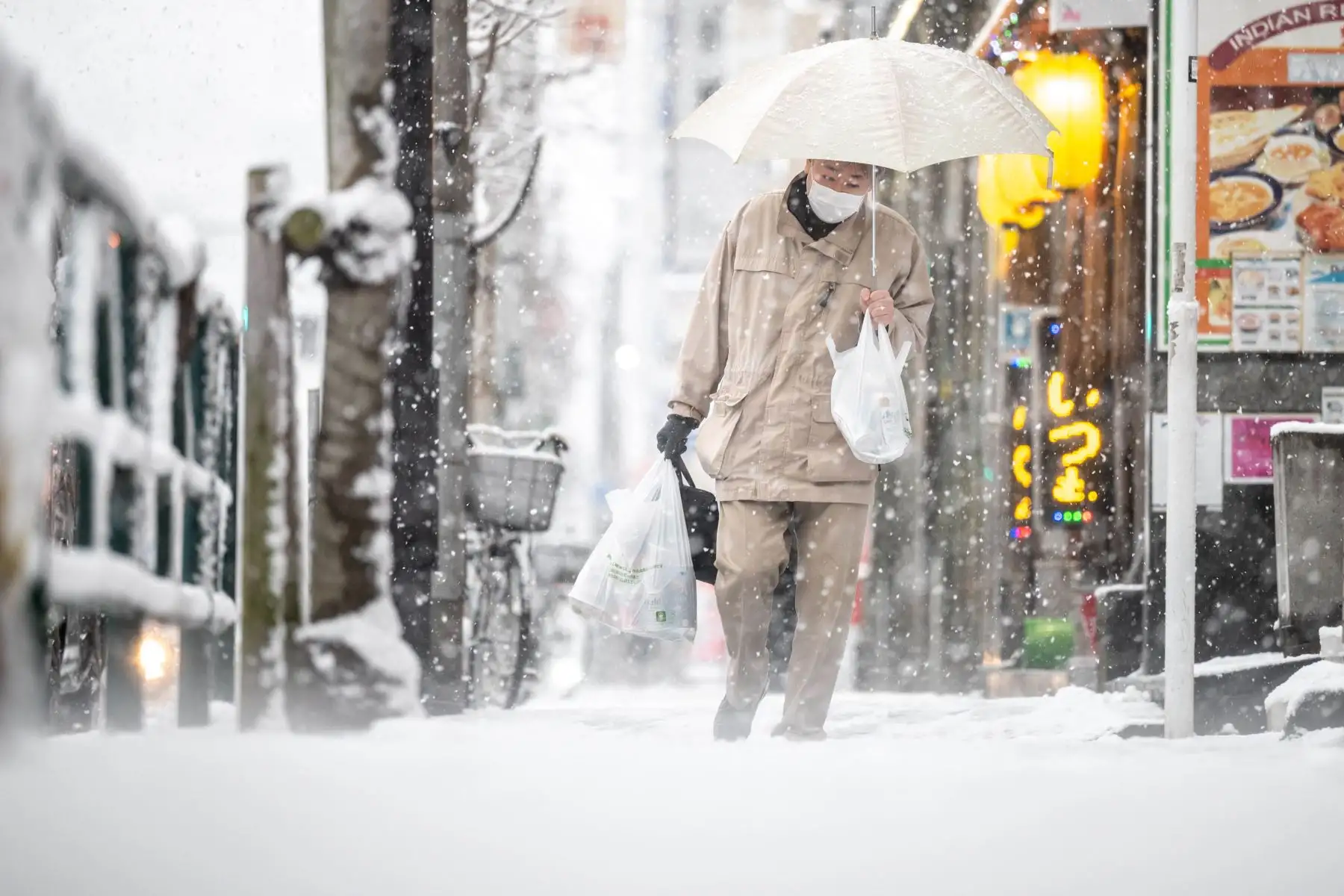 Un hombre camina en una calle mientras nieva en Tokio. Foto: AFP