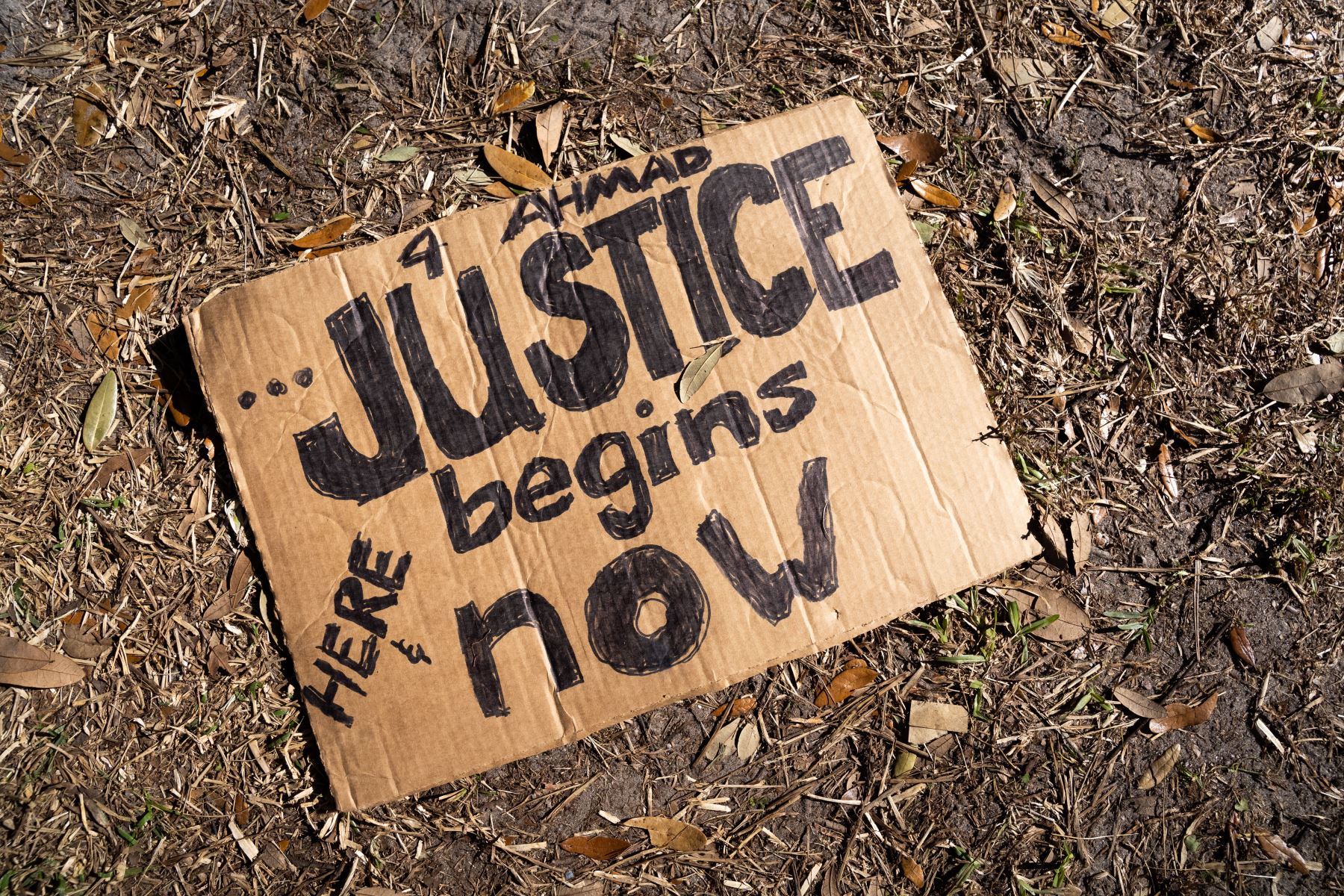 El cartel de Ahmaud Arbery se encuentra en el suelo fuera del Palacio de Justicia del Condado de Glynn, mientras el jurado delibera en el juicio de los asesinos el 24 de noviembre del 2021 en Brunswick, Georgia. Foto: AFP