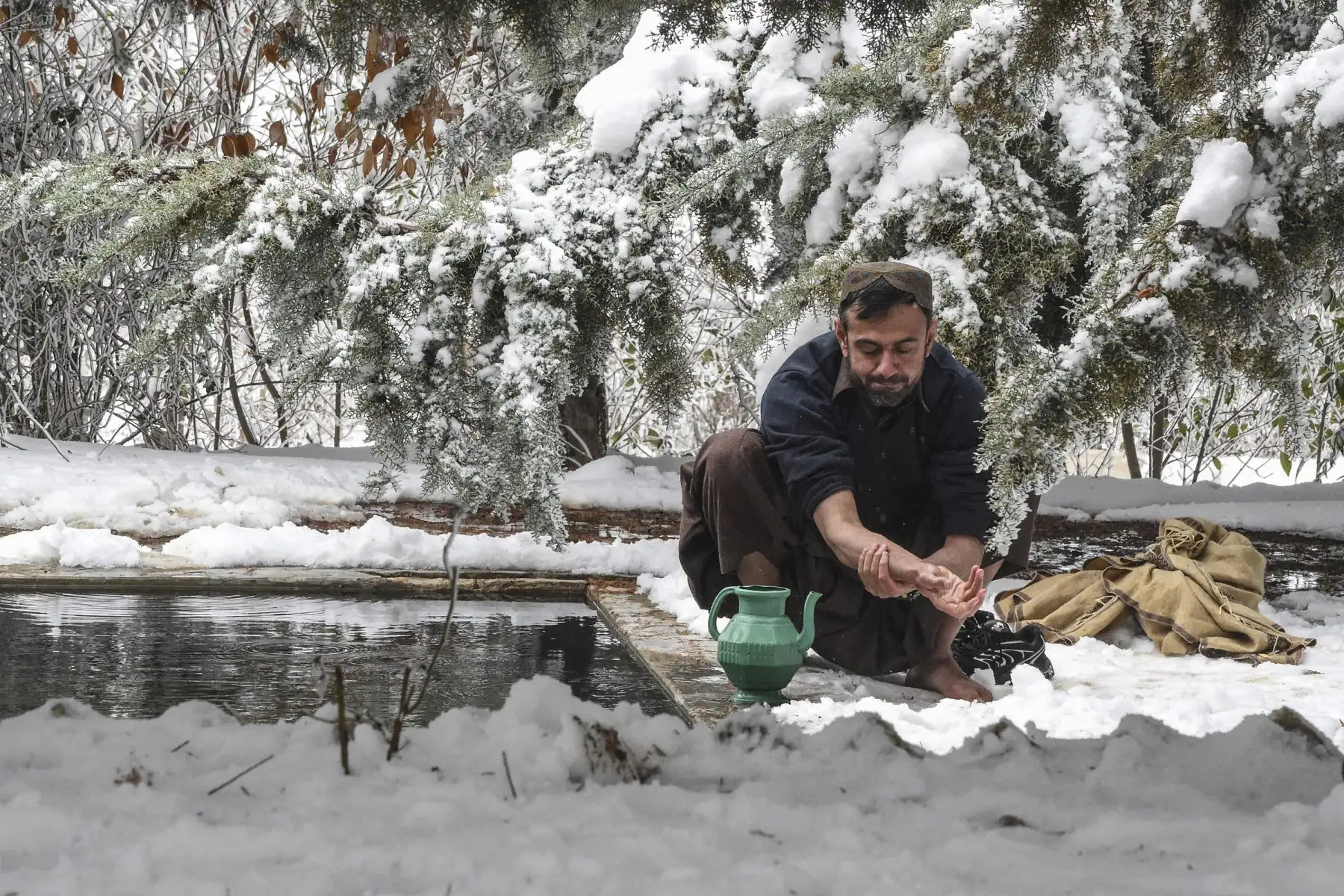 Un turista antes de ofrecer sus oraciones del mediodía en la zona nevada de Ziarat, Pakistan. Foto: AFP