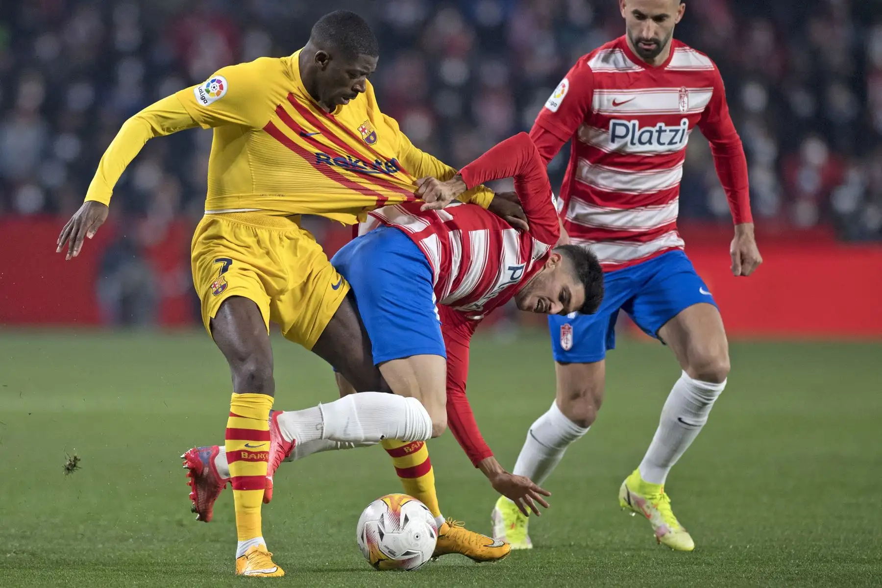 El delantero francés del Barcelona, Ousmane Dembele, compite con el defensa español del Granada Carlos Neva, en el Nuevo Estadio de Los Cármenes. Foto: AFP