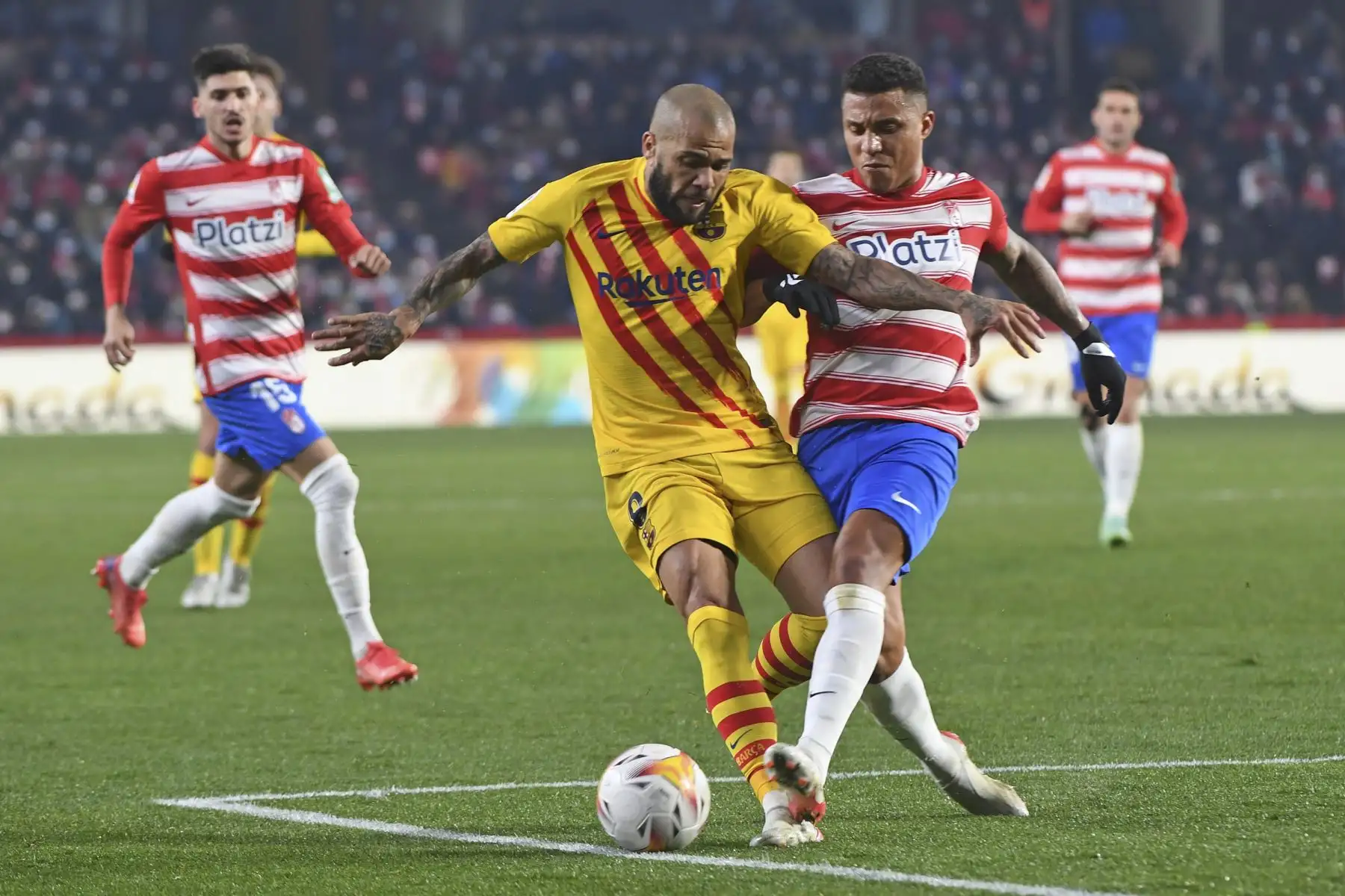 El defensa brasileño del Barcelona, Dani Alves, disputa ante el delantero venezolano del Granada, Darwin Machís, durante partido de LaLiga, en el Nuevo Estadio de Los Cármenes. Foto: AFP
