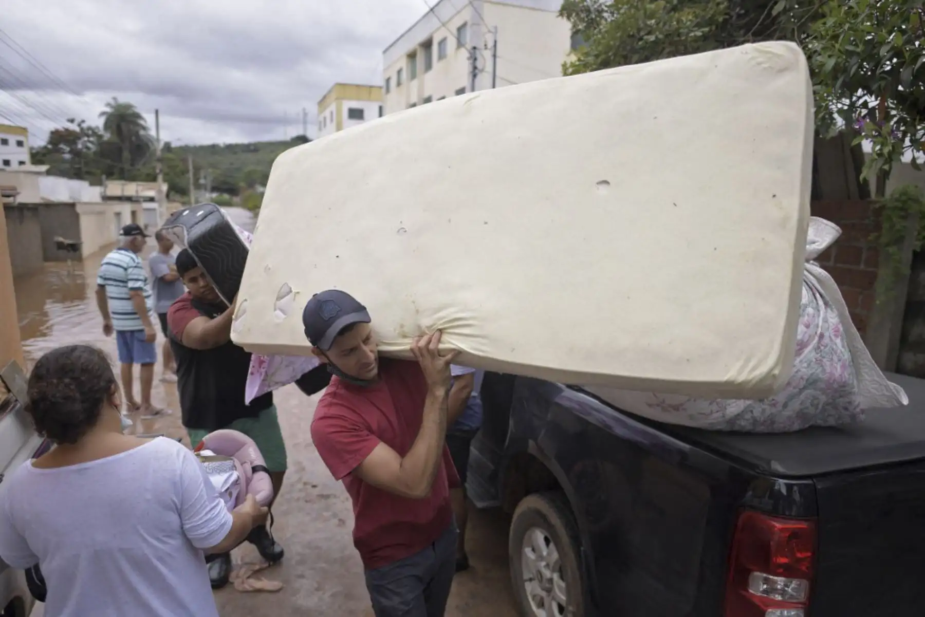 Personas retiran sus pertenencias de sus hogares en el inundado municipio brasileño de Juatuba, ubicado en el estado de Minas Gerais, el 10 de enero de 2022, luego de que cayeran lluvias extremadamente fuertes en los últimos días en la parte sureste del país. Foto: AFP