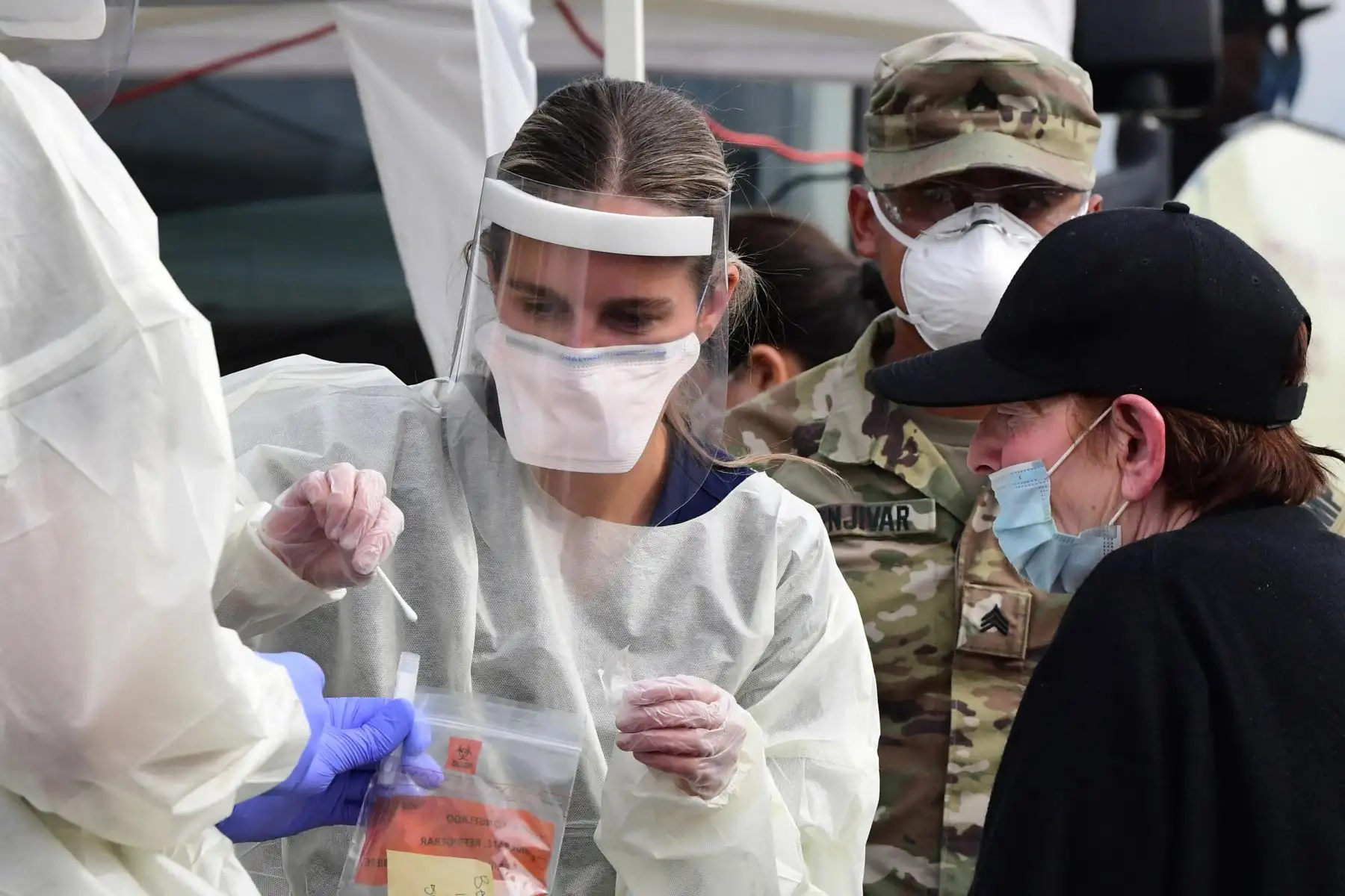 Una mujer recibe ayuda con un hisopo nasal en un sitio de prueba móvil BusTest Express Covid-19 en Paramount, una ciudad en el condado de Los Ángeles, California. Foto: AFP
