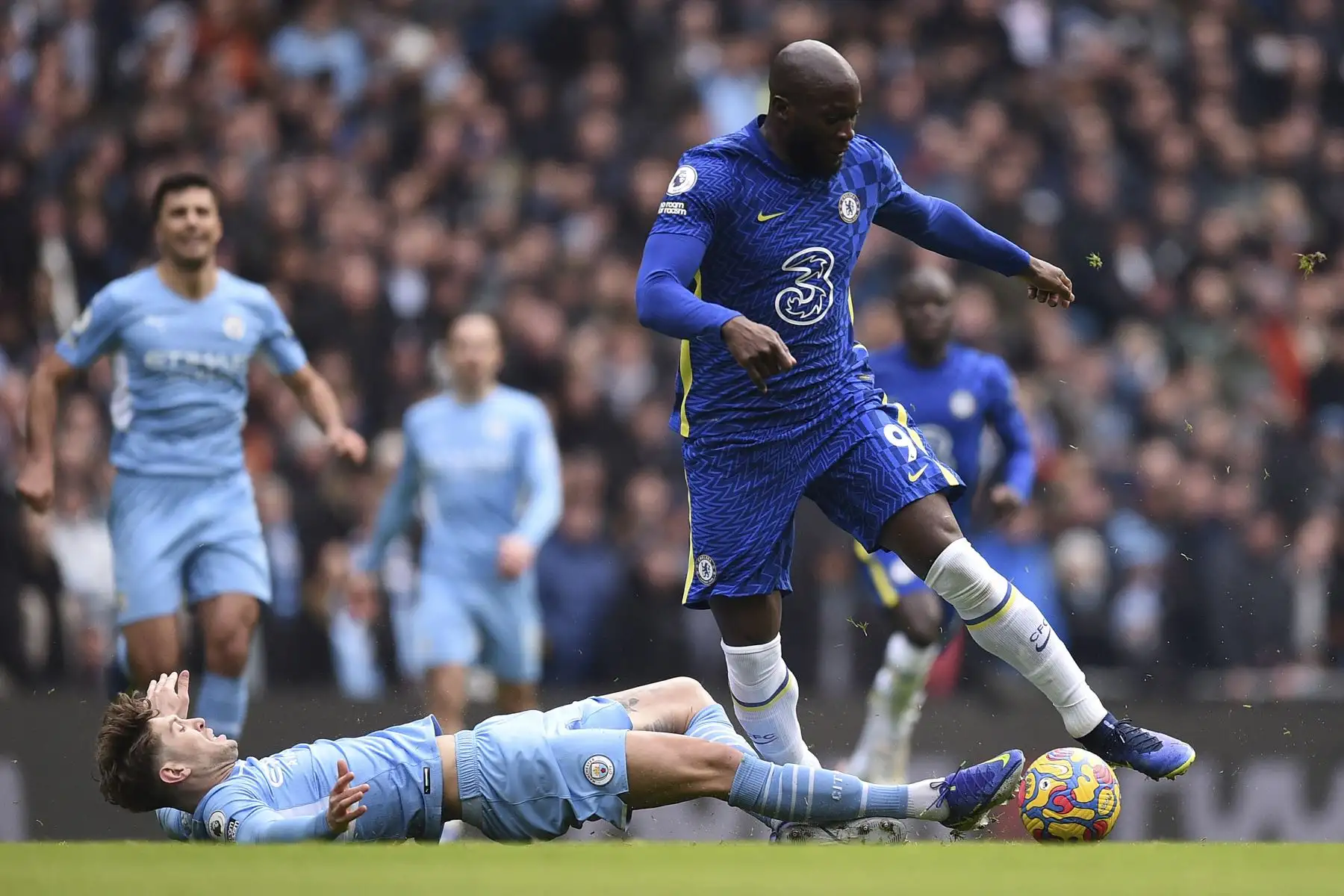 El defensor inglés del Manchester City, John Stones, aborda al delantero belga del Chelsea, Romelu Lukaku, durante el partido de la Premier League. Foto: AFP