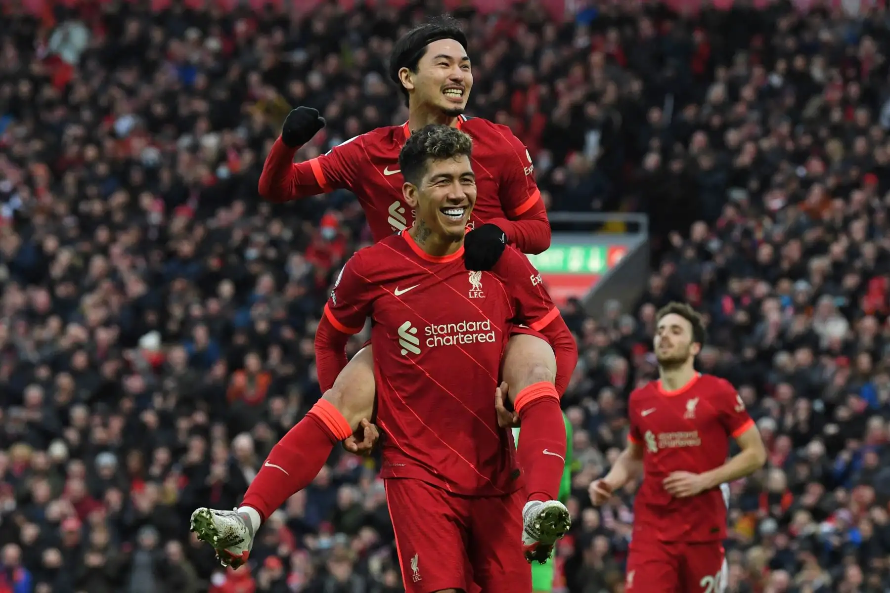 El mediocampista japonés del Liverpool, Takumi Minamino, ceebra con su compañero, Roberto Firmino, tras marcar el tercer gol de su equipo ante el Brentford por la Premier League. Foto: AFP