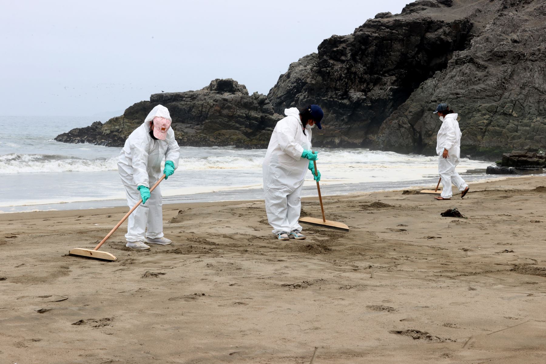 Trabajadores retiran los restos de petróleo de la orilla del mar. Foto: ANDINA/Vidal Tarqui
