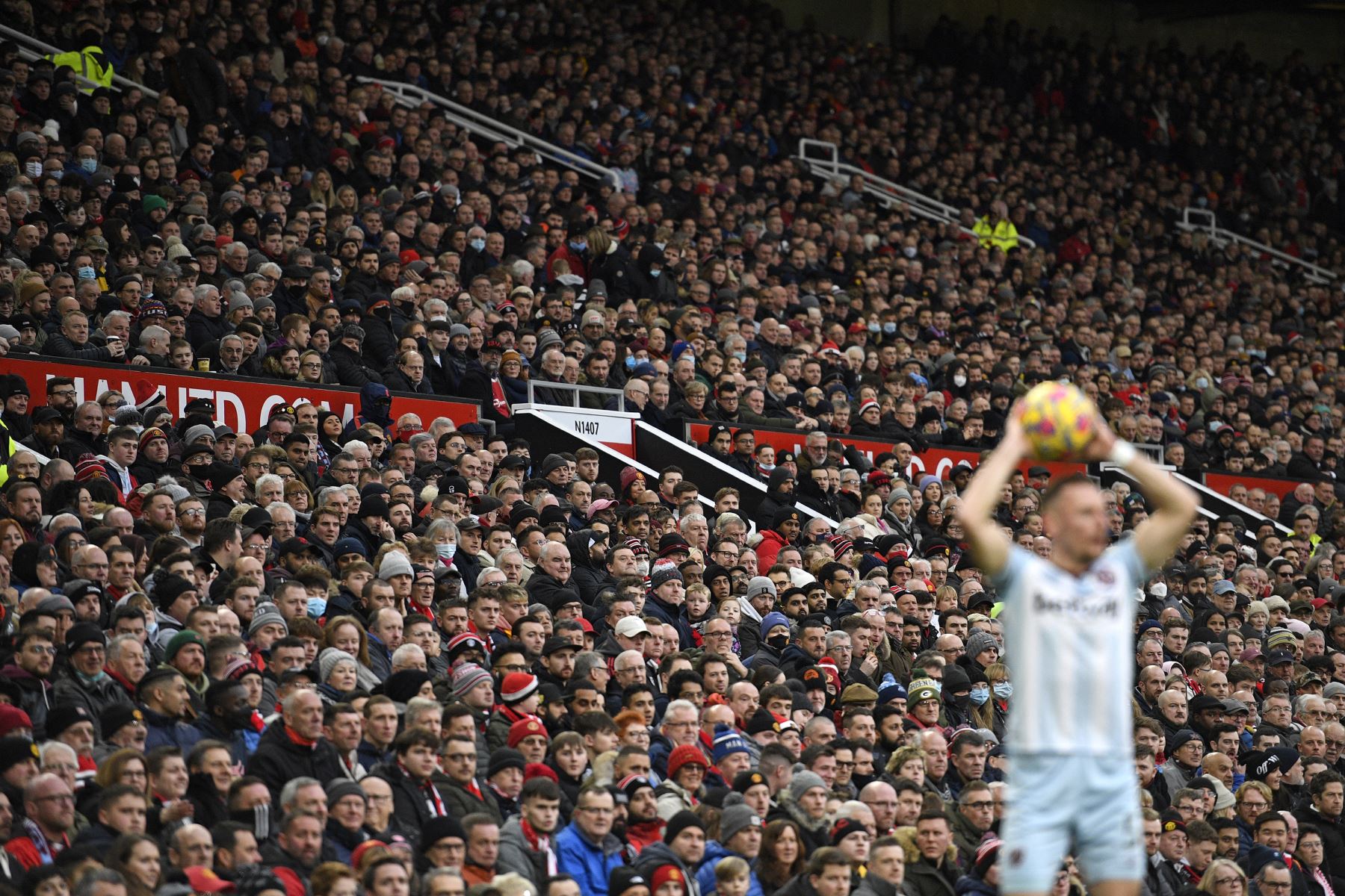 Los hinchas miran el partido desde la tribuna mientras un jugador hace un saque de banda durante el partido de la Premier League. Foto: AFP