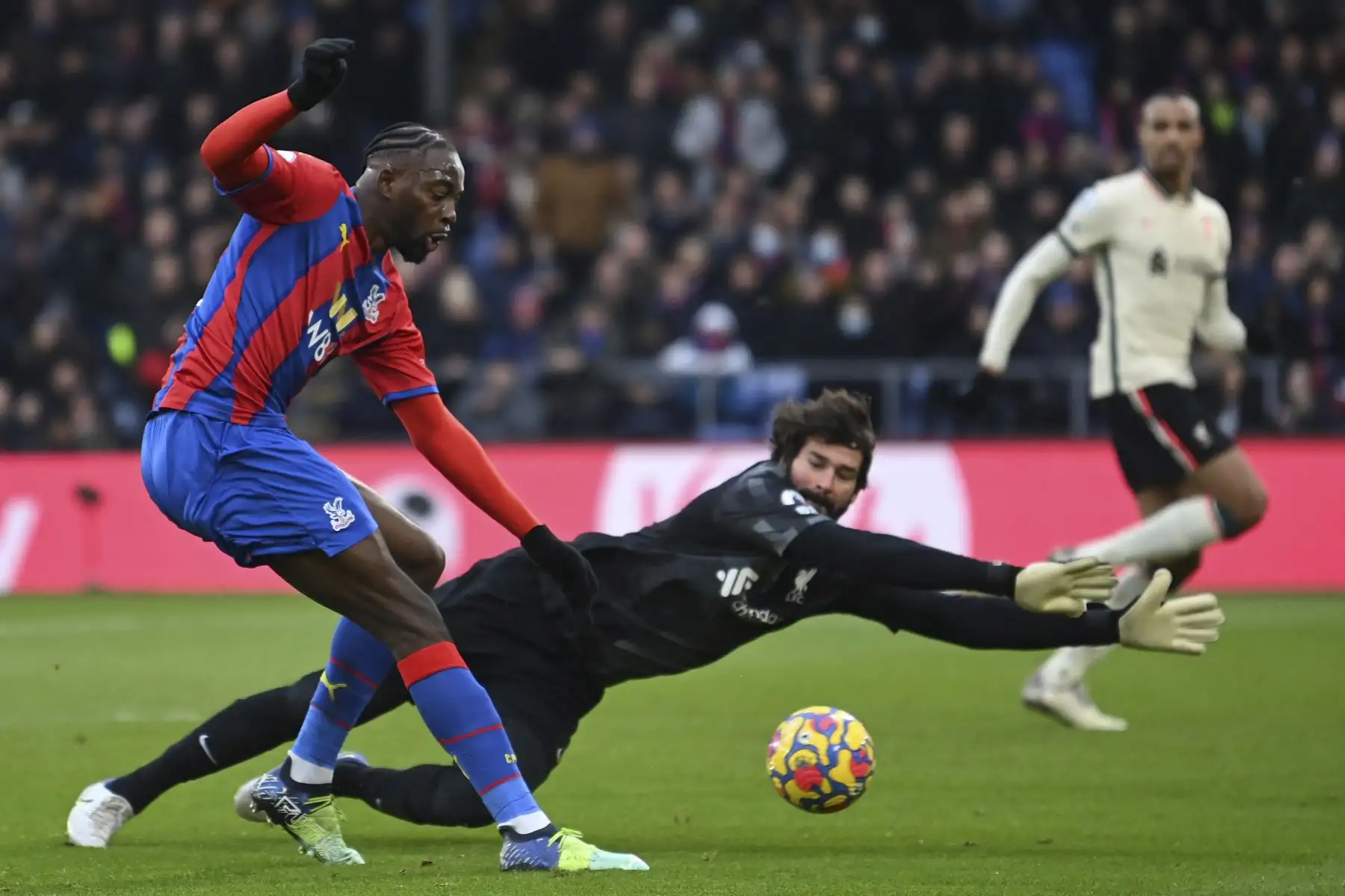 El delantero francés del Crystal Palace, Jean-Philippe Mateta, dispara pero no logra superar al portero brasileño del Liverpool, Alisson Becker, durante el partido de la Premier League. Foto: AFP