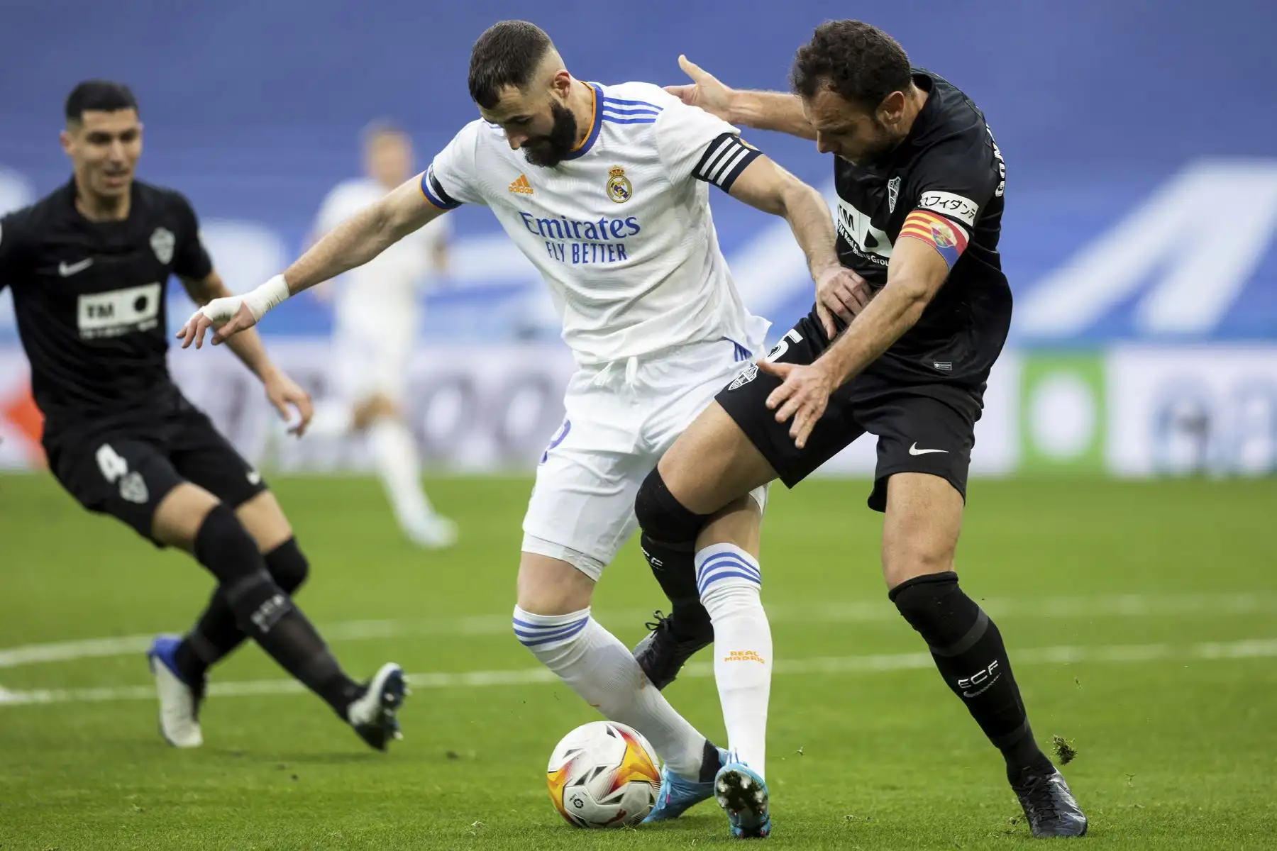 El delantero francés del Real Madrid, Karim Benzema, y el defensa del Elche, Gonzalo Verdú, disputan el balón durante el partido de La Liga Santander, en el estadio Santiago Bernabéu. Foto: EFE