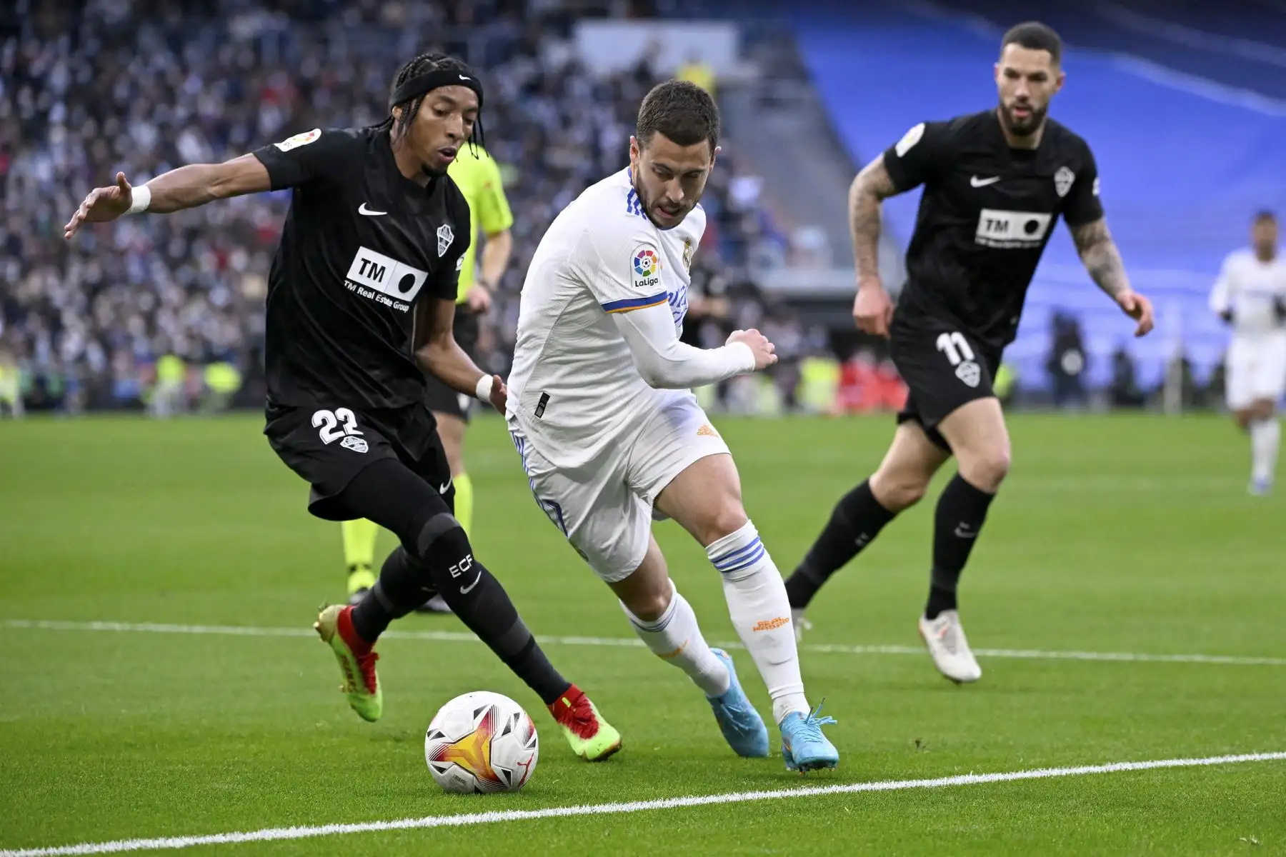 El defensor colombiano de Elche, Johan Mojica, compite con el delantero belga del Real Madrid, Eden Hazard, durante el partido de la liga española, en el Estadio Santiago Bernabéu. Foto: