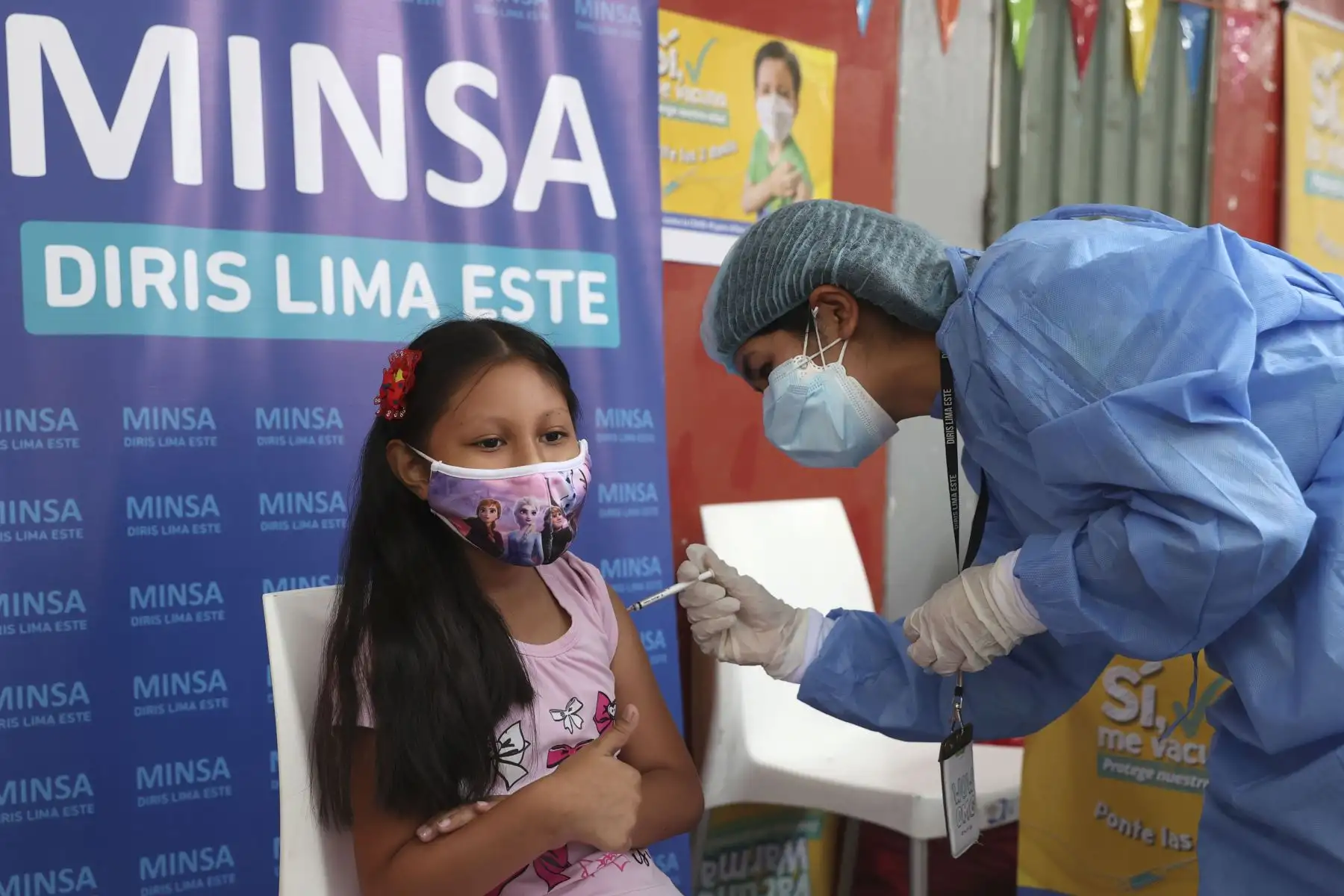 Mi princesa ya está protegida, alcanzó a decir la madre de esta niña, que acudió hoy temprano al colegio Carlos Mariategui, en el Agustino, para protegerse contra el covid-19. La pequeña lucía una mascarilla con la figura de sus personajes de ficción favoritas, las princesas de Disney. Foto: ANDINA/Vidal Tarqui