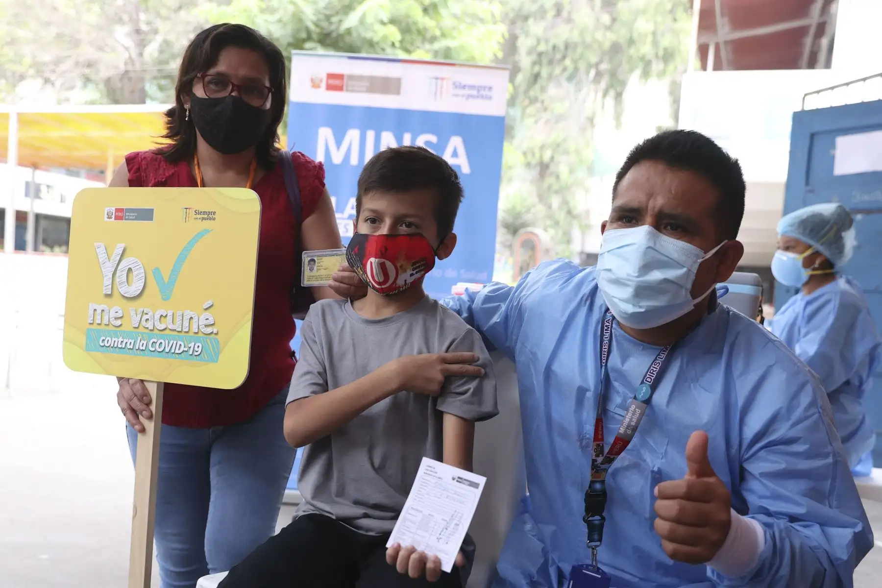 Con evidente entusiasmo acuden a vacunarse contra covid-19, niños de 5 a 11 años con comorbilidades y los menores de 10 y 11 años. Un pequeño hincha del club Universitario de Deportes posa junto a su madre con el clásico "Pongo el hombro". Foto: ANDINA/Vidal Tarqui.