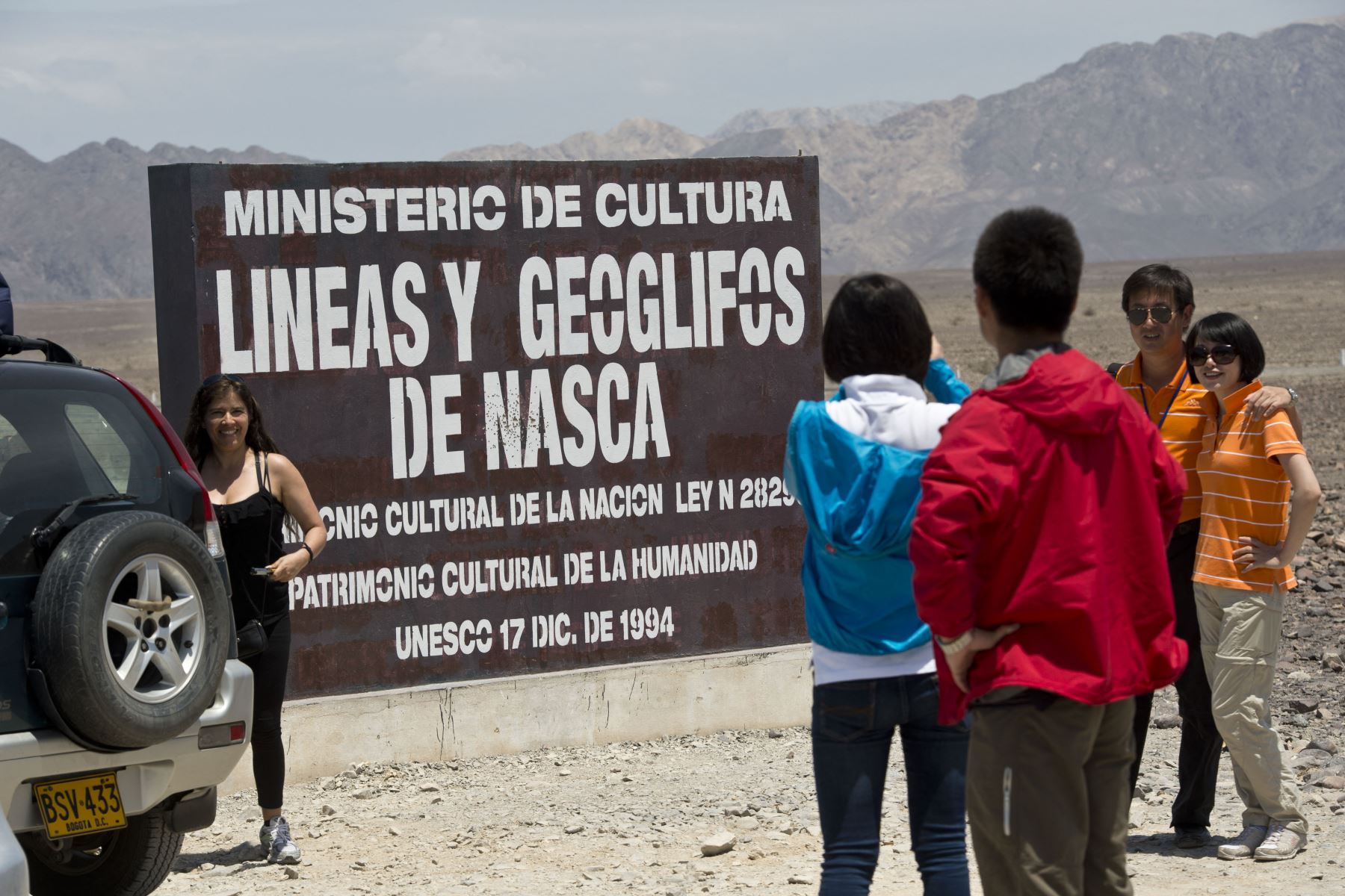 Un grupo de turistas posan para tomarse las fotografías familiares junto a un cartel en las Líneas de Nazca en Nazca, Perú. El turismo es una de las principales actividades económicas en esta provincia. Foto: AFP