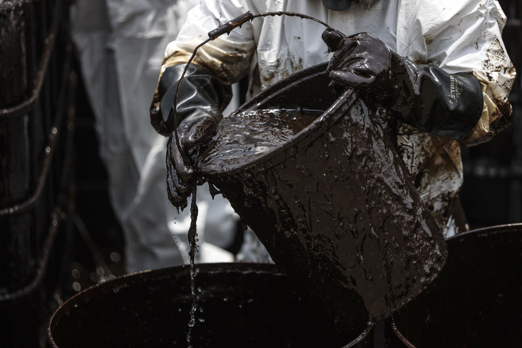 Los obreros retiran el petróleo en baldes y lo depositan en cilindros de metal. Foto: ANDINA/Jhonel Rodríguez Robles