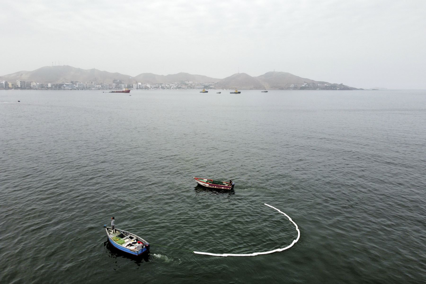 Trabajadores en botes usan una manga para extraer el petróleo del mar en la playa Positos en Ancón. Foto: ANDINA/Jhonel Rodríguez Robles