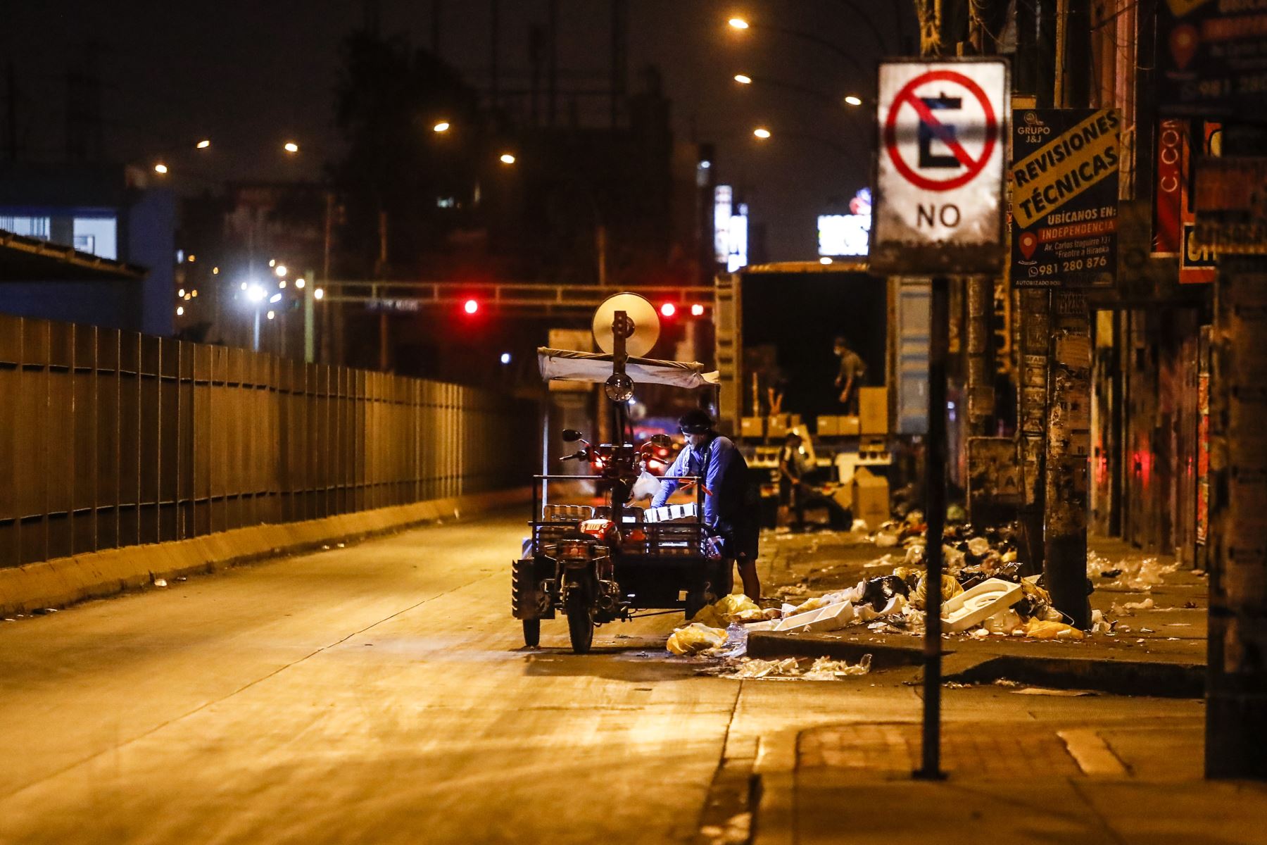 Un reciclador trabaja frente a la Estación Narajal, durante las últimas horas de la noche previo al Toque de queda que rige en Lima y Callao. Foto: ANDINA/Renato Pajuelo
