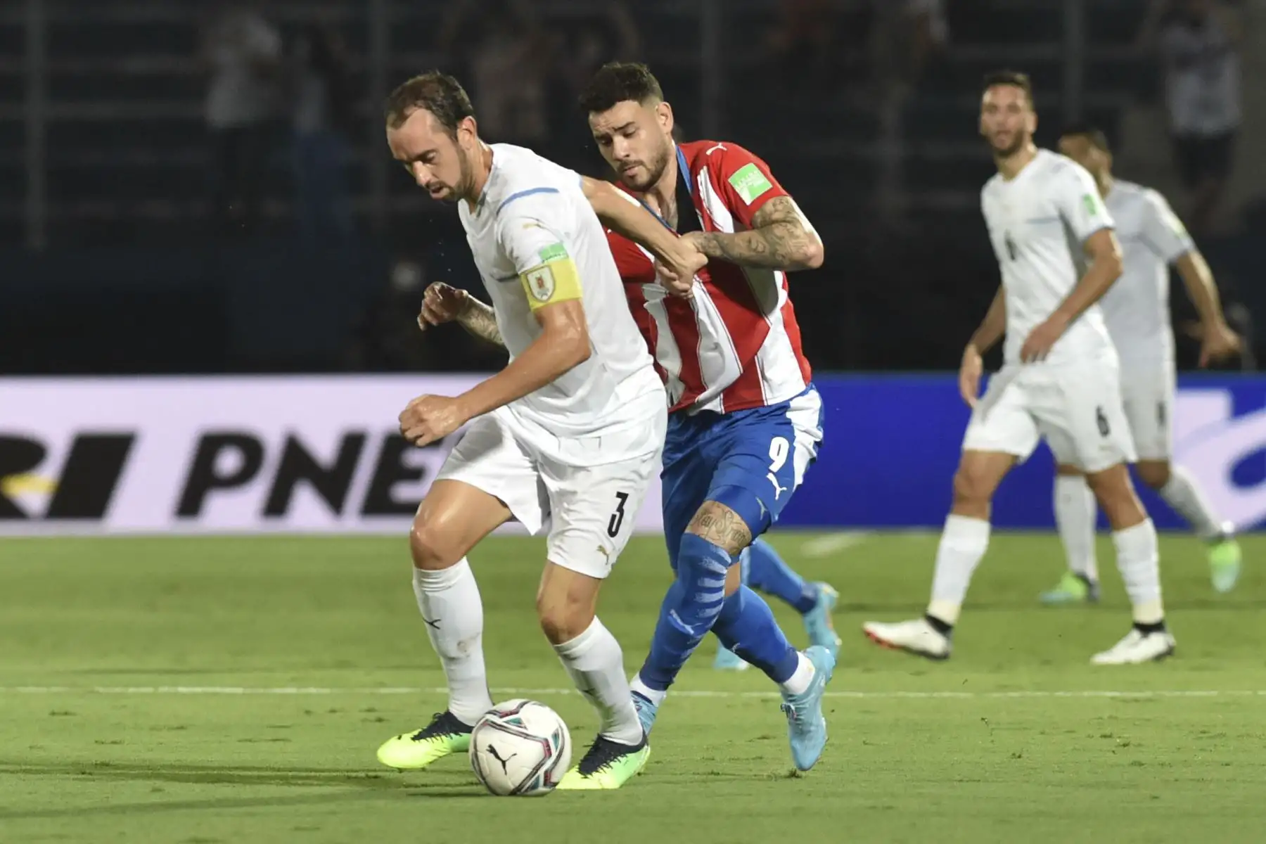 El uruguayo Diego Godin (izq.) y el paraguayo Antonio Sanabria (der.) disputan el balón durante el partido de clasificación sudamericano para la Copa Mundial de la FIFA Catar 2022 en el estadio General Pablo Rojas de Asunción. Foto: AFP