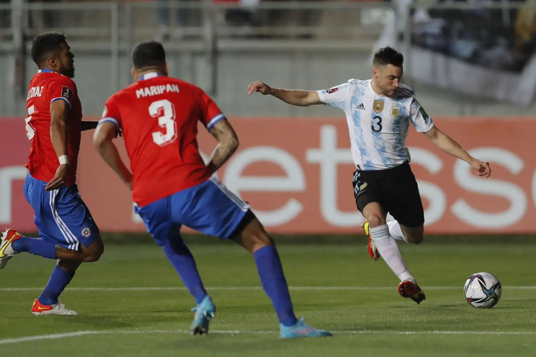 El argentino Nicolás Tagliafico y el chileno Paulo Díaz  compiten por el balón durante su partido clasificatorio sudamericano para la Copa Mundial Qatar 2022, en el Estadio Zorros del Desierto, en Calama, Chile. Foto: AFP