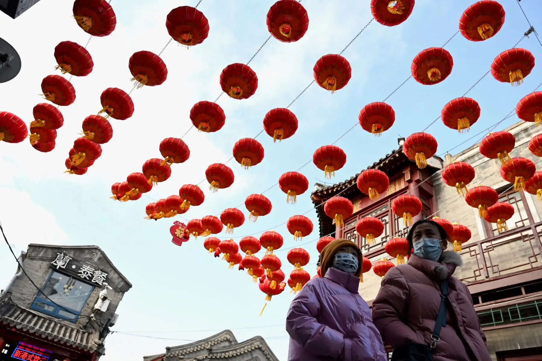 La gente camina bajo los faroles tradicionales un día antes del comienzo del Año Nuevo Lunar, que marca el comienzo del Año del Tigre, en Beijing, China. Foto: AFP