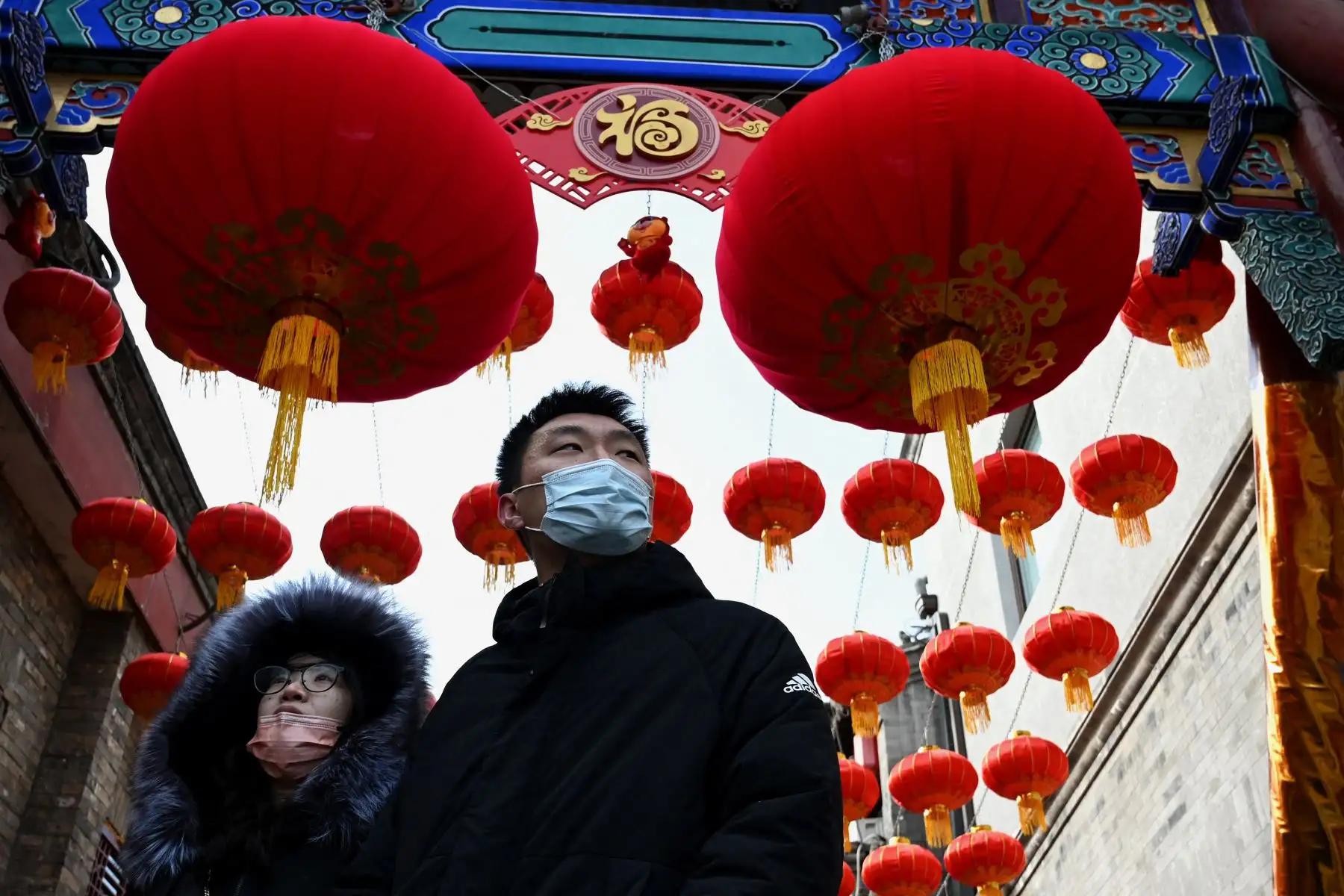 La gente camina bajo los faroles tradicionales un día antes del comienzo del Año Nuevo Lunar, que marca el comienzo del Año del Tigre, en Beijing, China. Foto: AFP