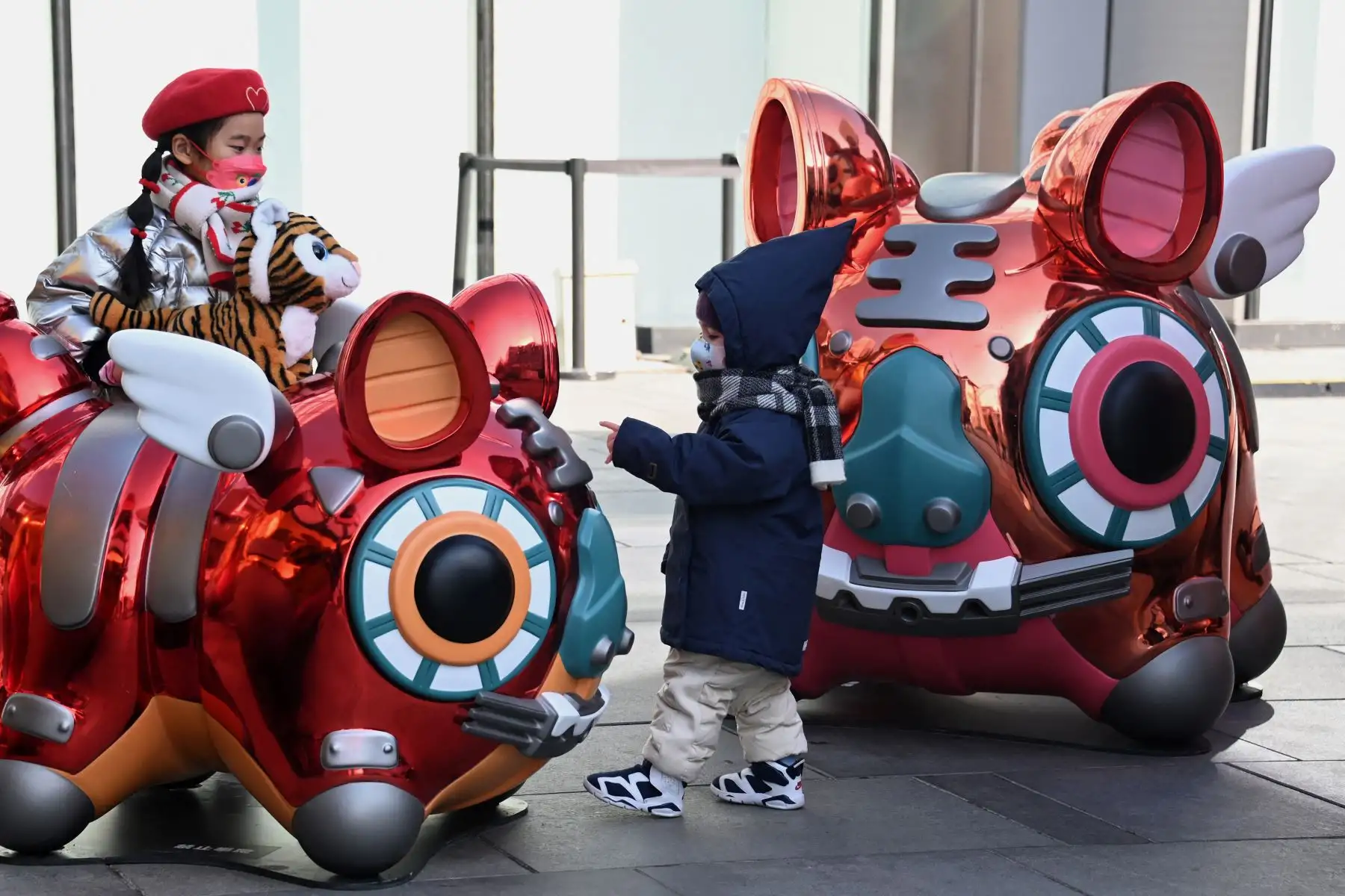 Niños juegan con estatuas de tigres antes del Año Nuevo Lunar del Tigre, en un centro comercial en Beijing. Foto: AFP