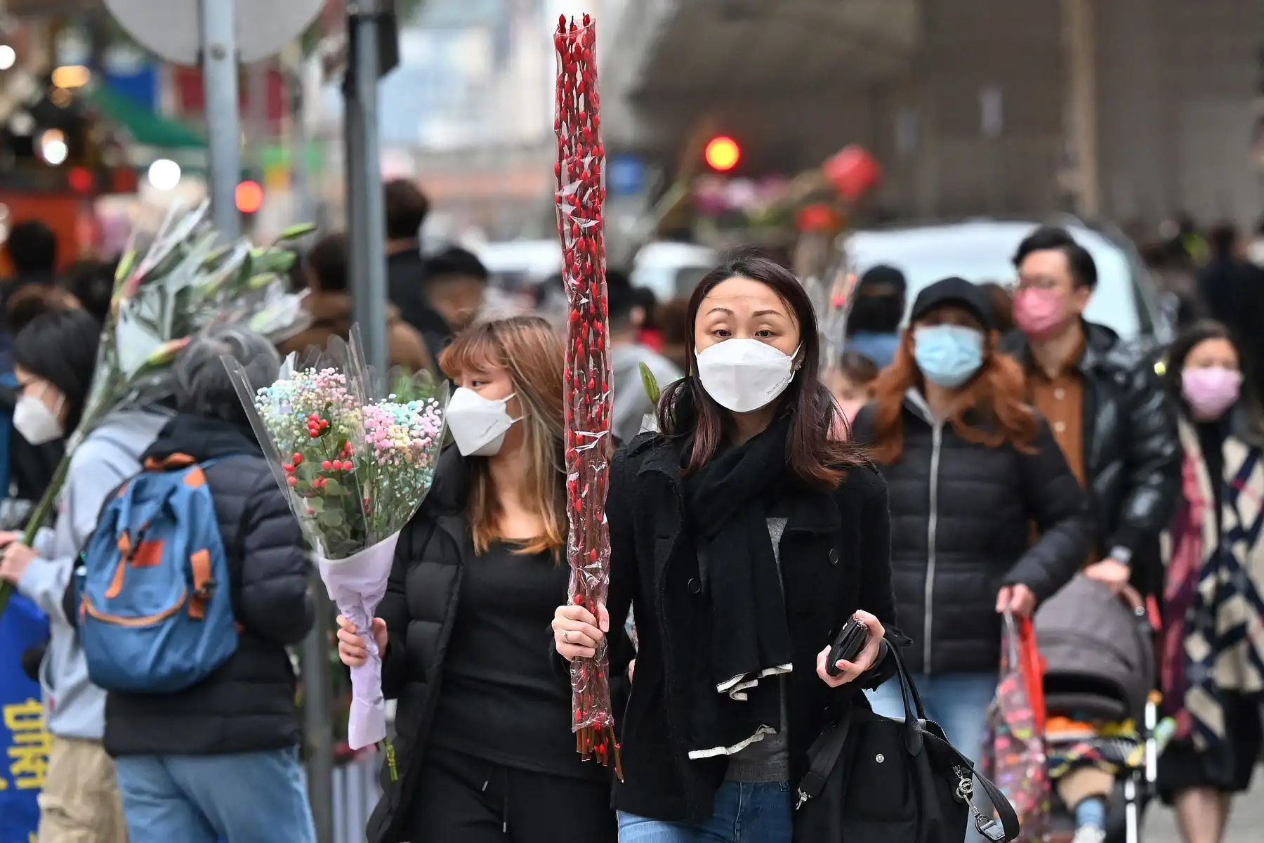 Un cliente camina con flores compradas antes del Año Nuevo Lunar en Hong Kong, que marca el comienzo del Año del Tigre. Foto: AFP