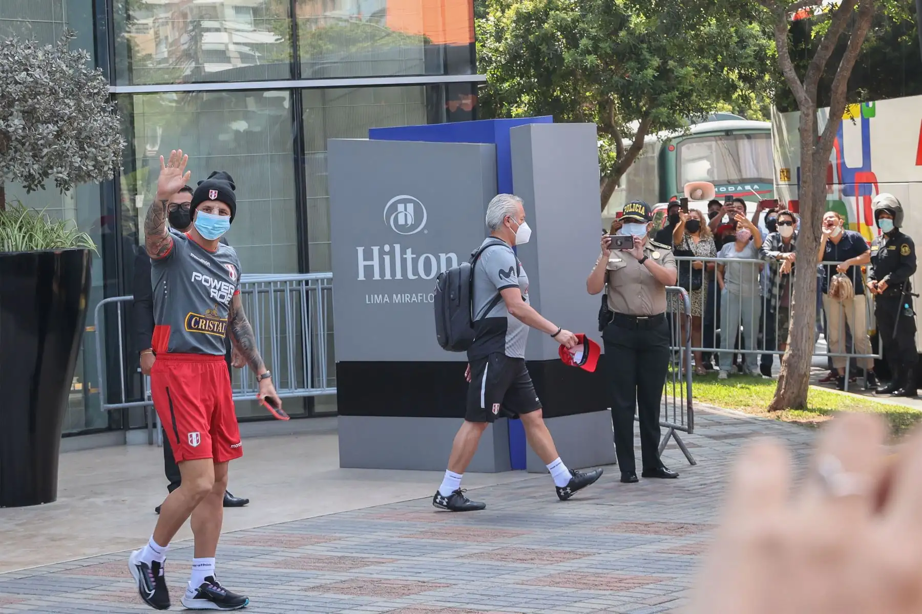 Con gorra negra y mascarilla, el delantero de la selección peruana Gianluca Lapadula saluda a los aficionados reunidos en los alrededores del hotel Hilton, en Miraflores. Aun con el tabique nasal desviado por un golpe en el partido con Colombia, el ‘Bambino’ ha expresado su deseo de pilotar el ataque peruano esta noche frente a Ecuador (21:00 horas, Estadio Nacional de Lima).
Foto: ANDINA/Andrés Valle