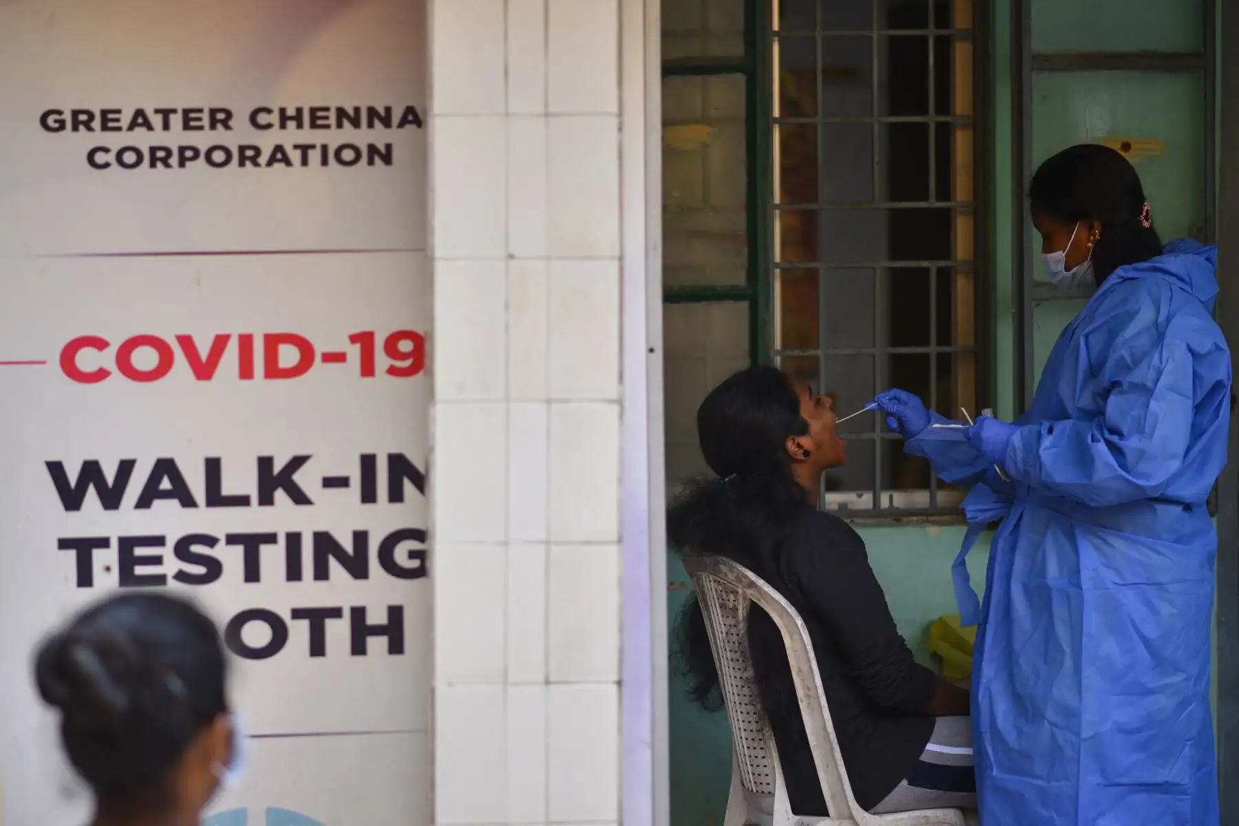 Un trabajador de la salud recolecta una muestra de hisopo de una mujer para una prueba de COVID-19, en un centro de salud en Chennai, India. Foto: EFE
