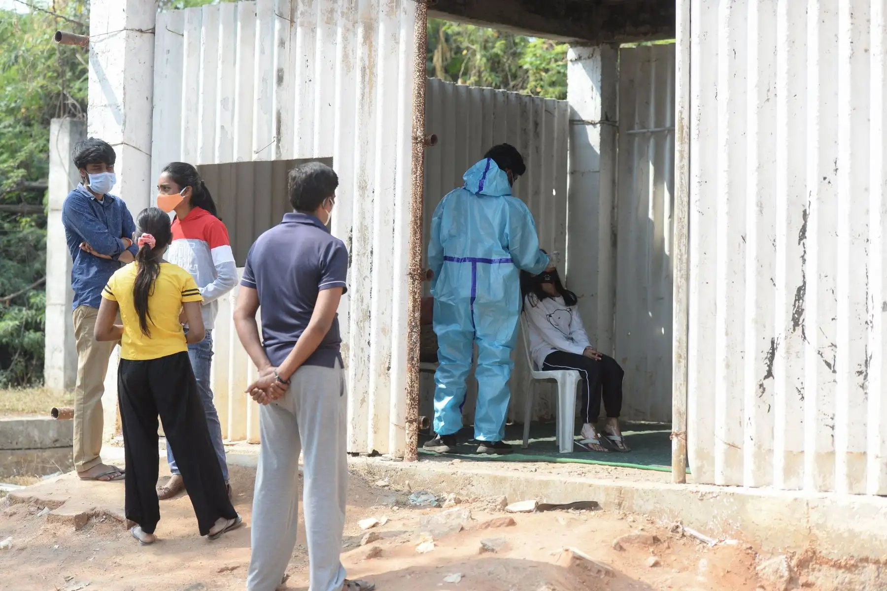 Un trabajador de la salud toma una muestra de hisopo de una mujer para realizar una prueba de detección de coronavirus Covid-19 en un campo abierto en Hyderabad,. India. Foto: AFP