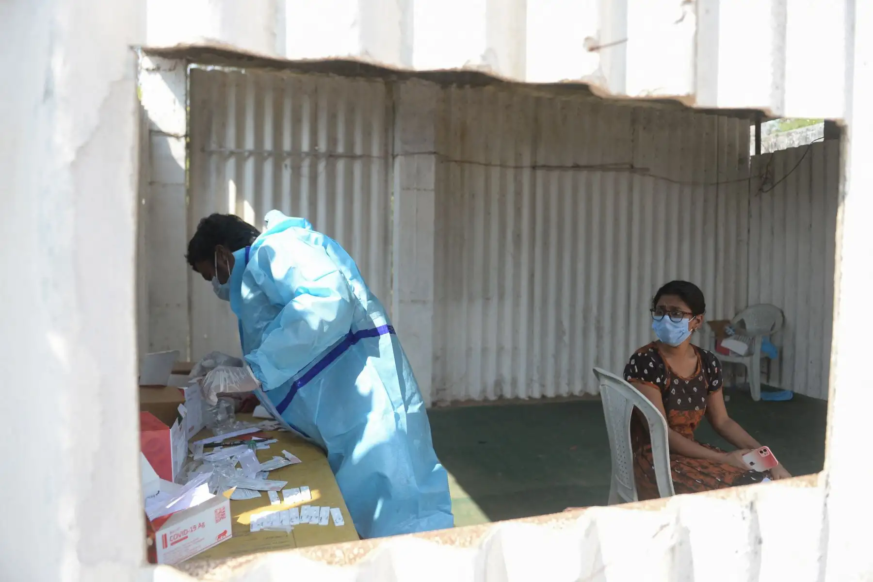 Un trabajador de la salud toma una muestra de hisopo de una mujer para realizar una prueba de detección de coronavirus Covid-19 en un campo abierto en Hyderabad,. India. Foto: AFP