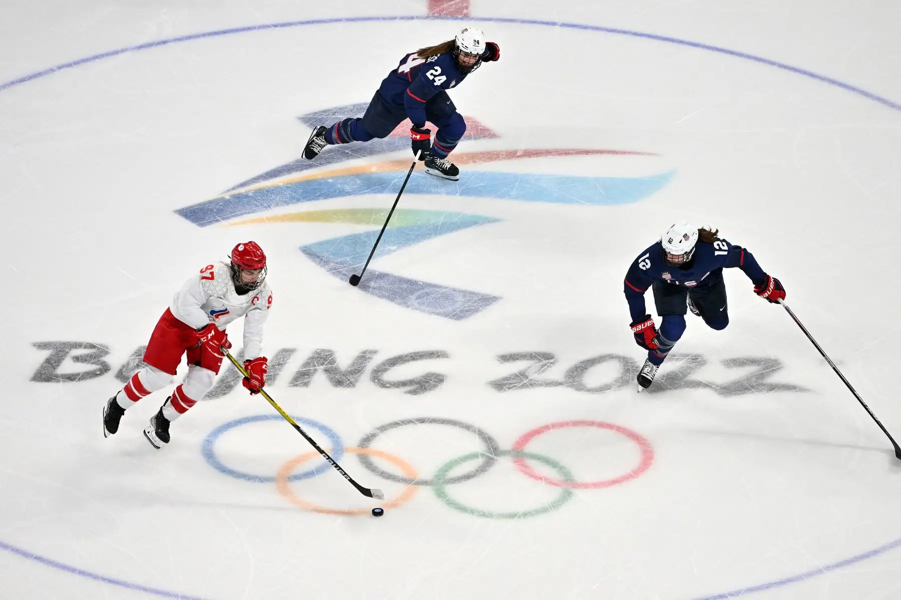 Anna Shokhina del Comité Olímpico Ruso es desafiada por Danielle Cameranesi y Kelly Pannek de EE. UU. durante el partido del grupo A de la ronda preliminar femenina de la competencia de hockey sobre hielo de los Juegos Olímpicos de Invierno de Beijing 2022.
Foto: AFP