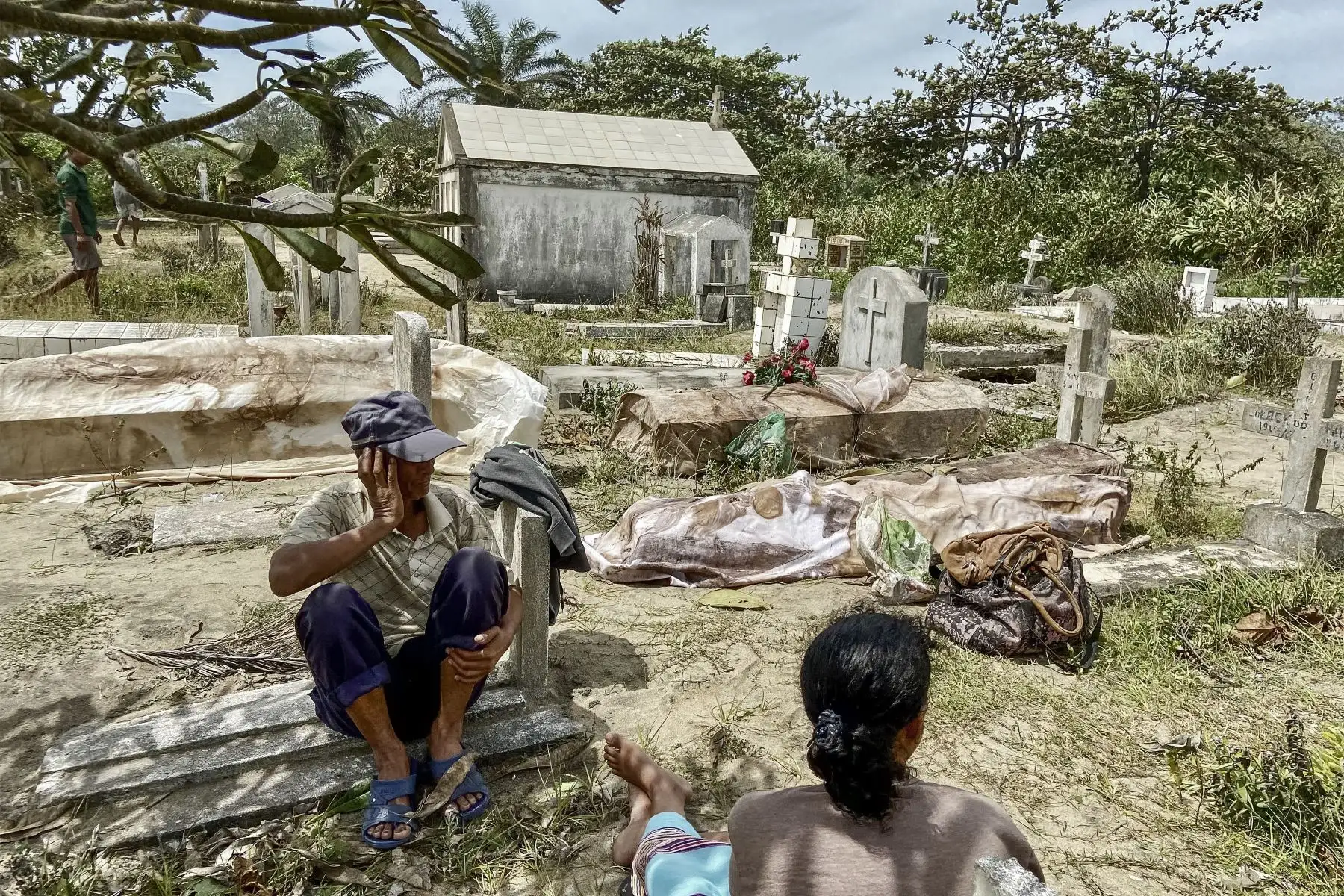 Los familiares se sientan junto a los cuerpos exhumados de las tumbas destruidas por el ciclón Batsirai en el cementerio local de Mahanoro.
Foto: AFP