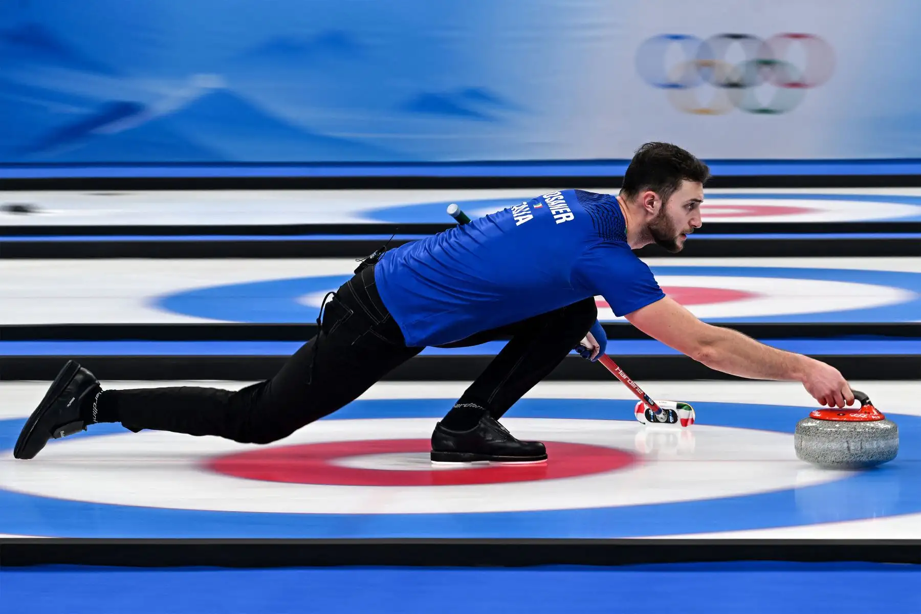 El italiano Amos Mosaner hace curl con la piedra durante el juego por la medalla de oro en dobles mixtos de la competencia de curling de los Juegos Olímpicos de Invierno de Beijing 2022.
Foto: AFP