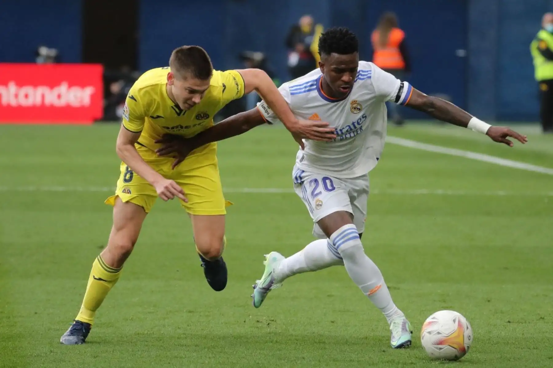 El delantero brasileño del Real Madrid, Vinicius Junior, compite con el defensa argentino del Villarreal, Juan Foyth, durante el partido de fútbol de la liga española entre el Villarreal CF y el Real Madrid CF en el estadio La Ceramica de Vila-real el 12 de febrero de 2022. Foto: AFP