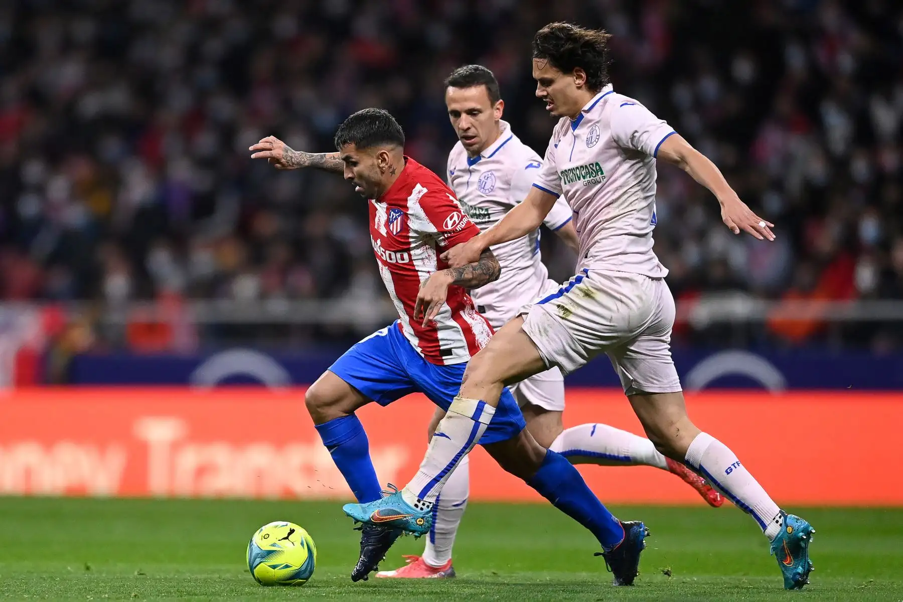 El delantero argentino del Atlético de Madrid Ángel Correa lucha por el balón con el delantero turco de Getafe Enes Unal  durante el partido de fútbol de la liga española entre el Club Atlético de Madrid y el Getafe. Foto: AFP