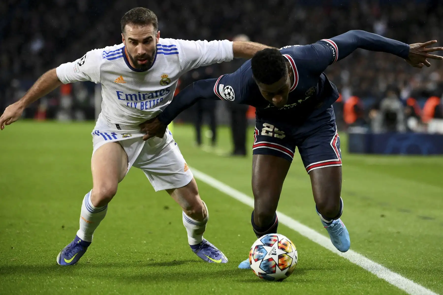 El defensor portugués del Paris Saint-Germain Nuno Mendes (R) y el defensor español del Real Madrid Dani Carvajal (L) luchan por el balón durante el partido de ida de octavos de final de la Liga de Campeones de la UEFA entre el Paris Saint-Germain (PSG) y el Real Madrid en el Estadio Parc des Princes en París el 15 de febrero de 2022. Foto: AFP