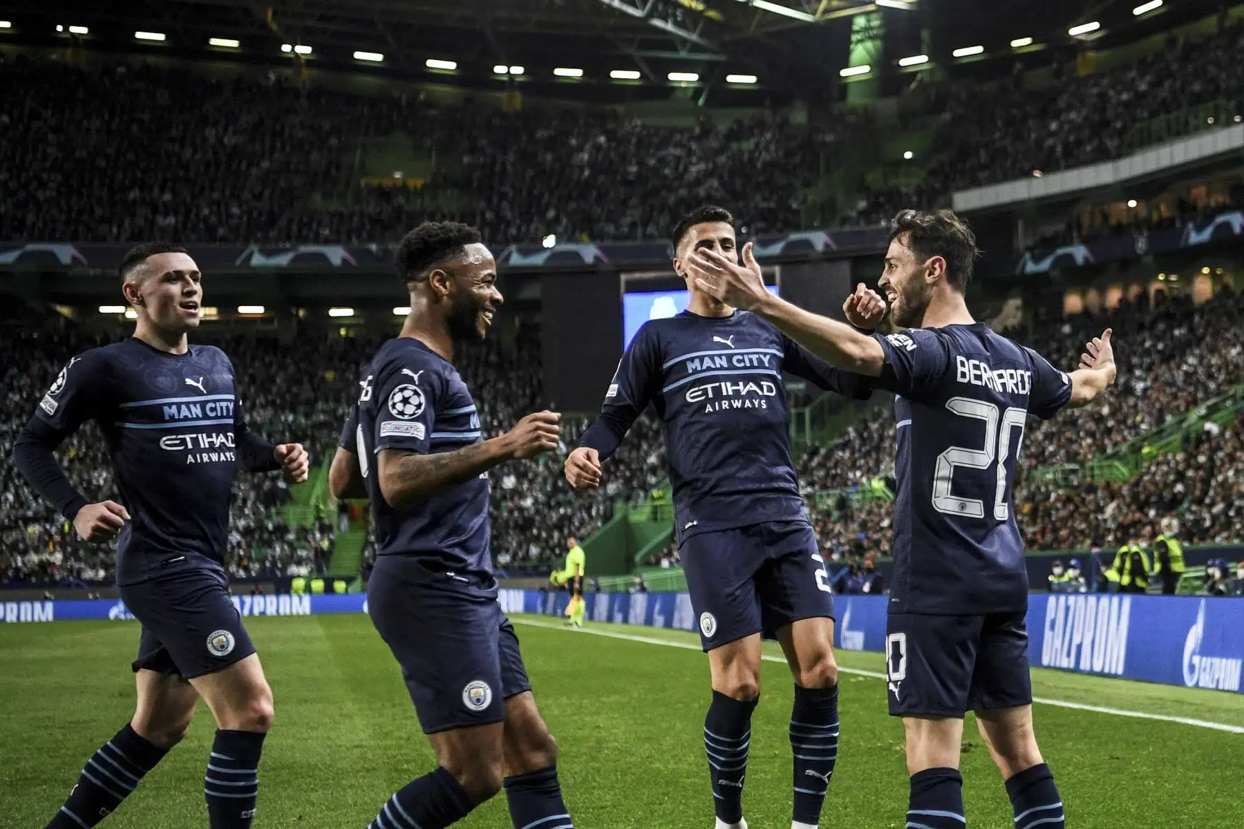 El centrocampista portugués del Manchester City Bernardo Silva (R) celebra con sus compañeros de equipo después de marcar el cuarto gol de su equipo durante el partido de ida de octavos de final de la Liga de Campeones de la UEFA entre el Sporting CP y el Manchester City en el estadio José Alvalade de Lisboa el 15 de febrero de 2022. Foto: AFP