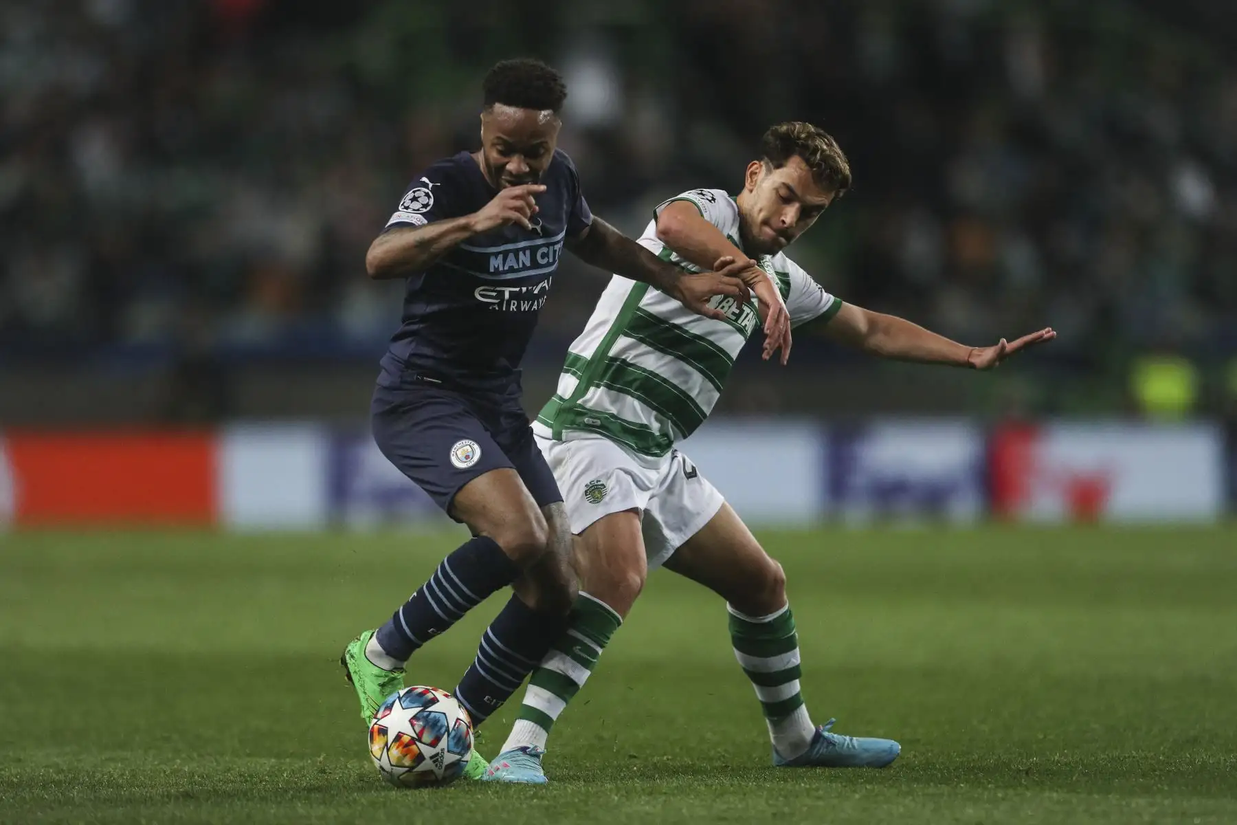 El mediocampista inglés del Manchester City, Raheem Sterling (L), lucha por el balón con el mediocampista portugués del Sporting de Lisboa, Pedro Goncalves, durante el partido de ida de octavos de final de la Liga de Campeones de la UEFA entre el Sporting CP y el Manchester City en el estadio José Alvalade de Lisboa el 15 de febrero de 2022. Foto: AFP