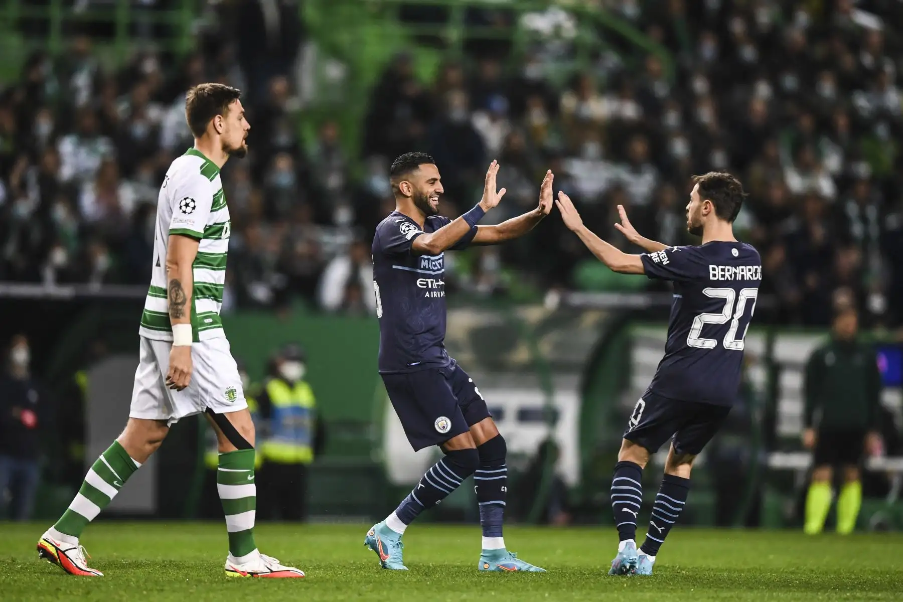 El mediocampista argelino del Manchester City, Riyad Mahrez (L), celebra con el mediocampista portugués del Manchester City, Bernardo Silva, después de marcar el primer gol de su equipo durante el partido de ida de los octavos de final de la Liga de Campeones de la UEFA entre el Sporting CP y el Manchester City en el estadio José Alvalade de Lisboa en febrero. 15 de febrero de 2022. Foto: AFP