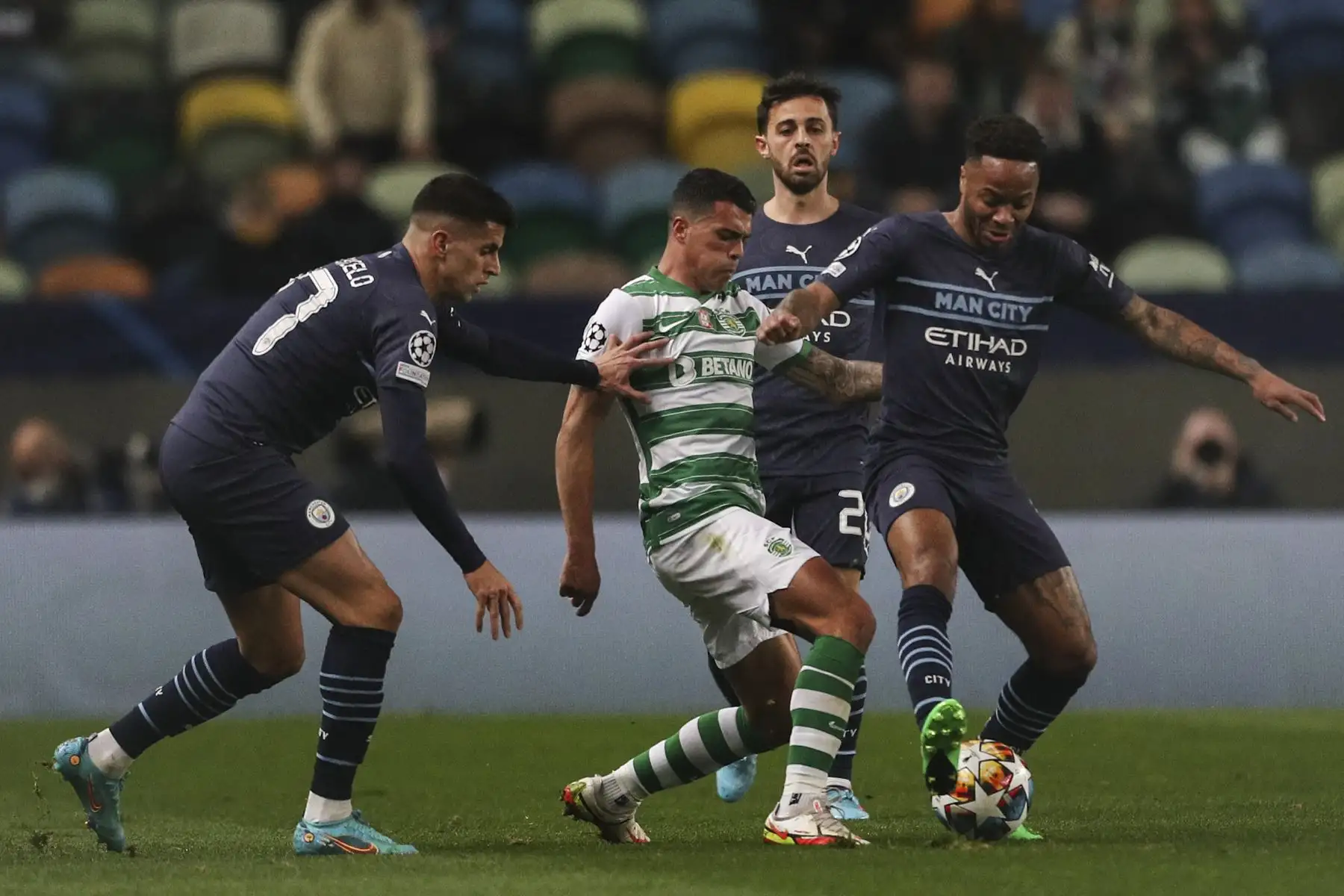 El defensa español del Sporting de Lisboa, Pedro Porro (centro), lucha por el balón con el centrocampista inglés del Manchester City, Raheem Sterling (der.), el defensa portugués del Manchester City, Joao Cancelo (izq.) y el centrocampista portugués del Manchester City, Bernardo Silva, durante el partido de ida de los octavos de final de la Liga de Campeones de la UEFA. partido de fútbol entre Sporting CP y Manchester City en el estadio José Alvalade de Lisboa el 15 de febrero de 2022. Foto: AFP