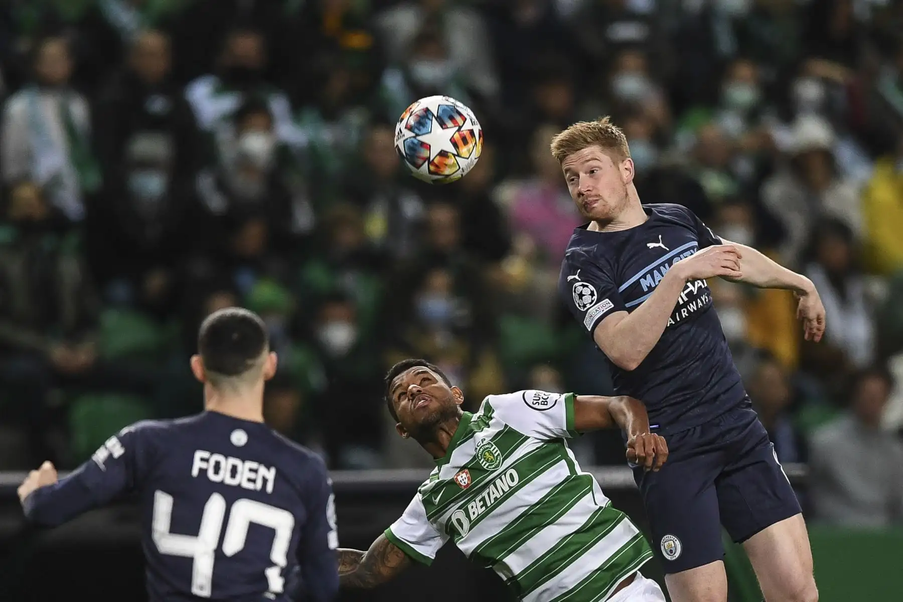 El defensor brasileño del Sporting de Lisboa, Matheus Reis (centro), y el centrocampista belga del Manchester City, Kevin De Bruyne (der.), encabezan el balón durante el partido de ida de octavos de final de la Liga de Campeones de la UEFA entre el Sporting CP y el Manchester City en el estadio José Alvalade de Lisboa el febrero 15 de febrero de 2022. Foto: AFP