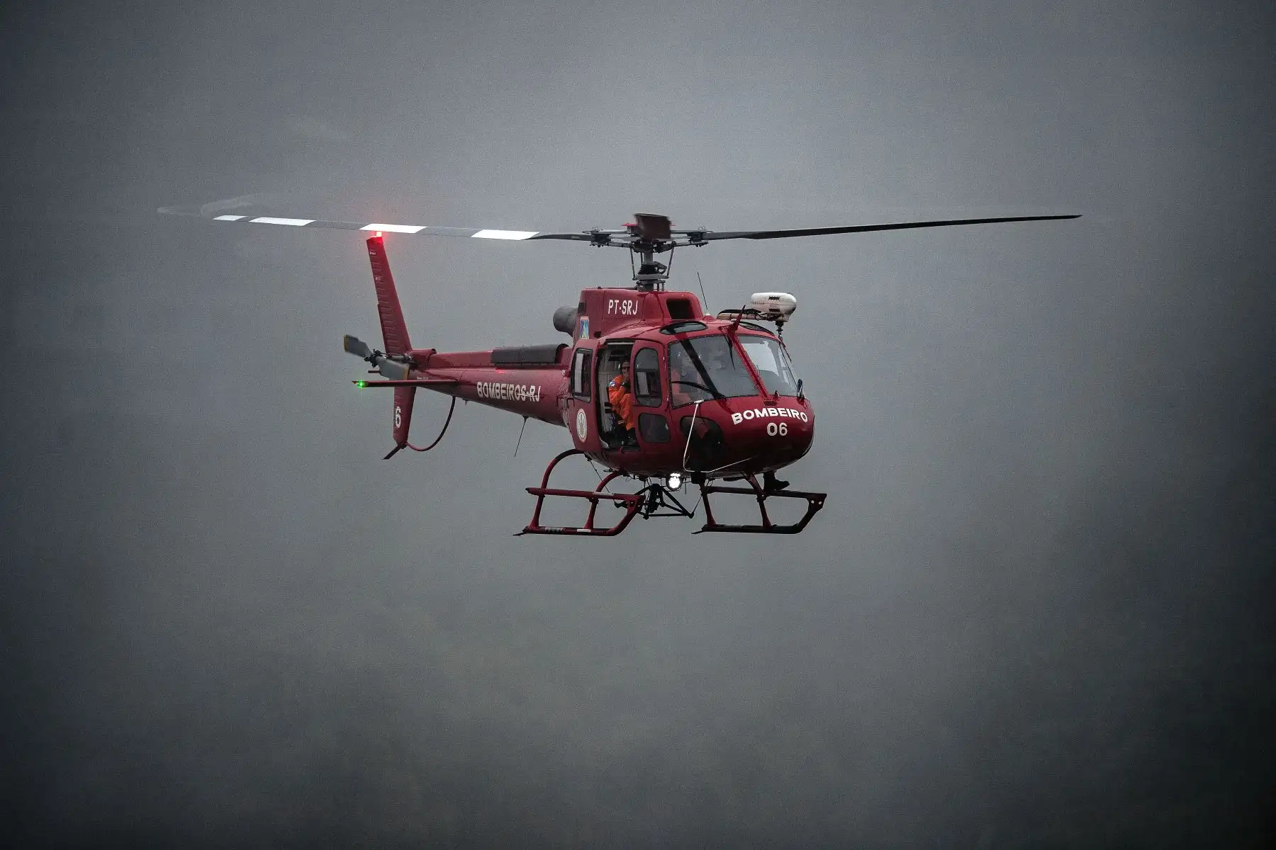 Un helicóptero de un equipo de rescate de los servicios de bomberos sobrevuela un área de un deslizamiento de tierra en busca de sobrevivientes en Petrópolis, Brasil. Foto: AFP