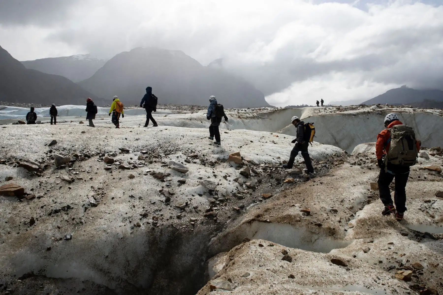 Funcionarios de la Corporación Nacional Forestal (CONAF), científicos y periodistas caminan por los alrededores del glaciar Exploradores, situado en el Parque Nacional Laguna San Rafael, en la sureña región de Aysén (Chile). Foto: EFE
