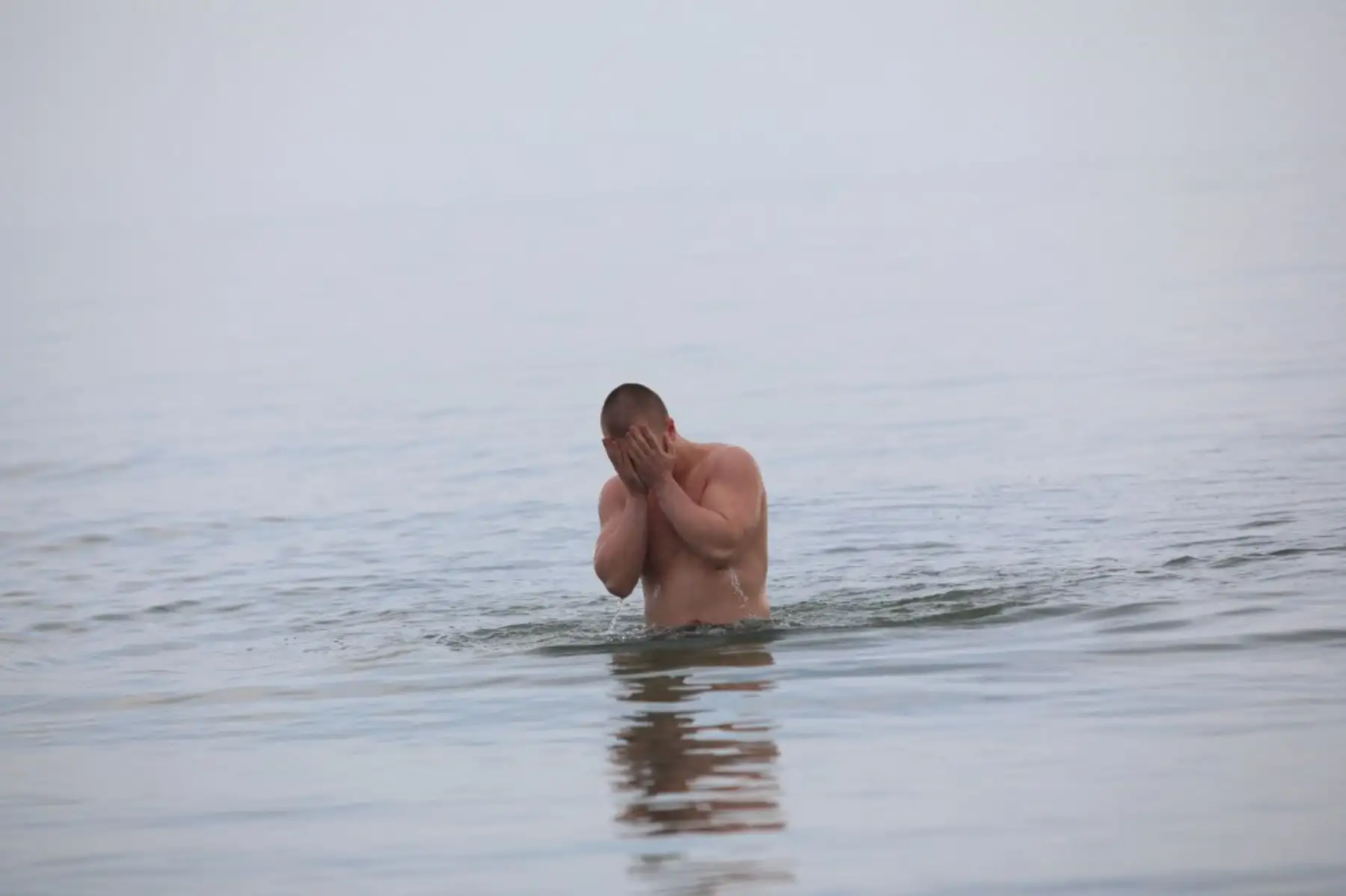 Un hombre nada en el Mar de Azov en la ciudad portuaria industrial de Mariupol en Ucrania el 23 de febrero de 2022.  Mariupol se encuentra en el borde de la línea del frente que separa el territorio controlado por el gobierno del supervisado por los separatistas respaldados por Rusia en el bastión rebelde Donetsk. Foto: AFP