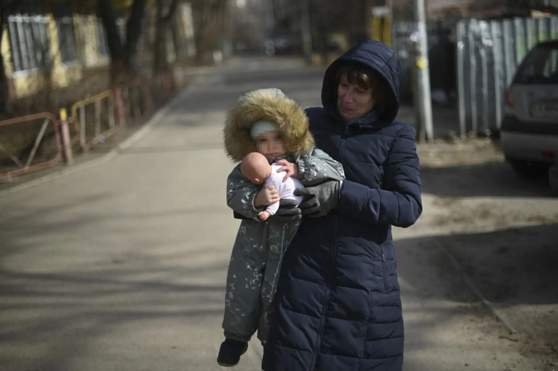 Una mujer llora mientras lleva a un niño al este de Kiev, el 23 de febrero de 2022. Occidente impuso sanciones económicas a Moscú después que el presidente ruso reconociera el 21 de febrero las regiones separatistas de Donetsk y Lugansk en Ucrania como estados independientes. Foto: AFP