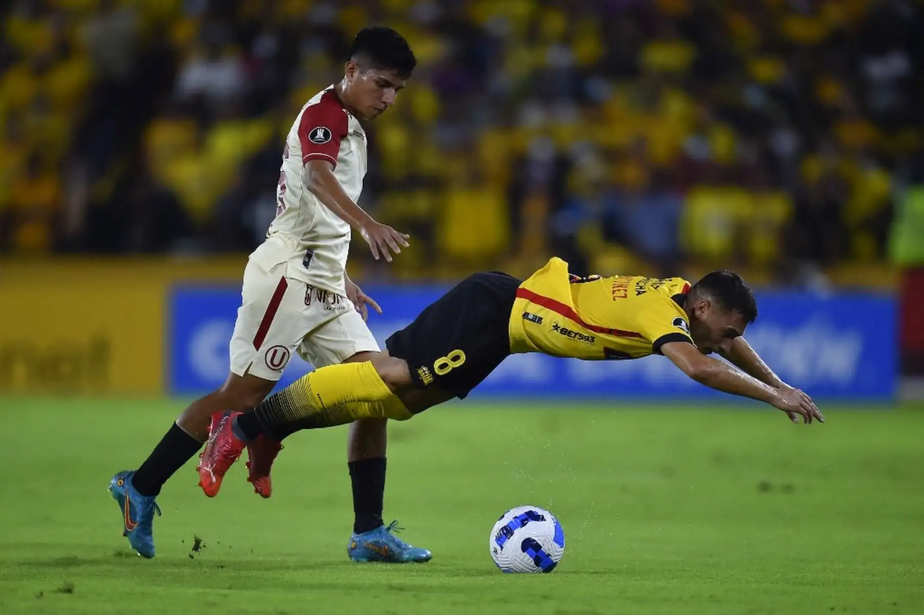 El peruano de Universitario Piero Quispe y el ecuatoriano Barcelona argentino Emmanuel Martínez compiten por el balón durante su partido de fútbol de la Copa Libertadores en el estadio Monumental de Guayaquil en Guayaquil, Ecuador, el 23 de febrero de 2022. (Foto de Rodrigo BUENDIA / AFP )