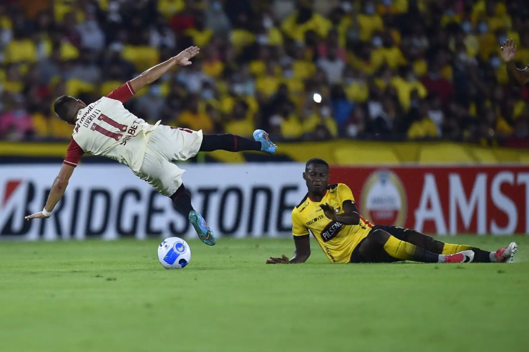 El jugador uruguayo de Universitario Luis Urruti de Perú y el Barcelona Leonel Quiñónez de Ecuador compiten por el balón durante su partido de fútbol de la Copa Libertadores en el estadio Monumental de Guayaquil en Guayaquil, Ecuador, el 23 de febrero de 2022. (Foto de Rodrigo BUENDIA / AFP )