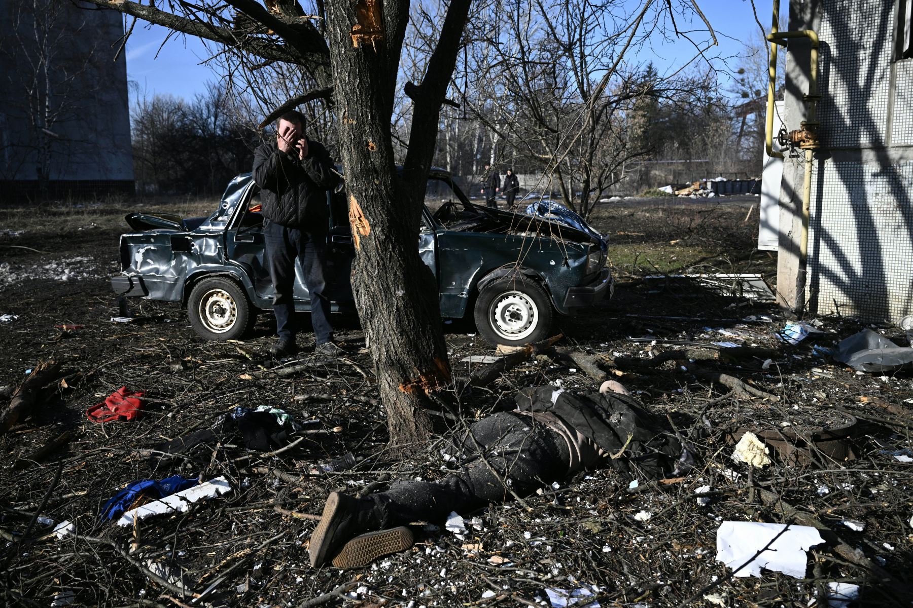 Un hombre reacciona mientras está de pie junto a un cuerpo tendido en el suelo después de los bombardeos en la ciudad de Chuguiv, en el este de Ucrania. Foto: AFP